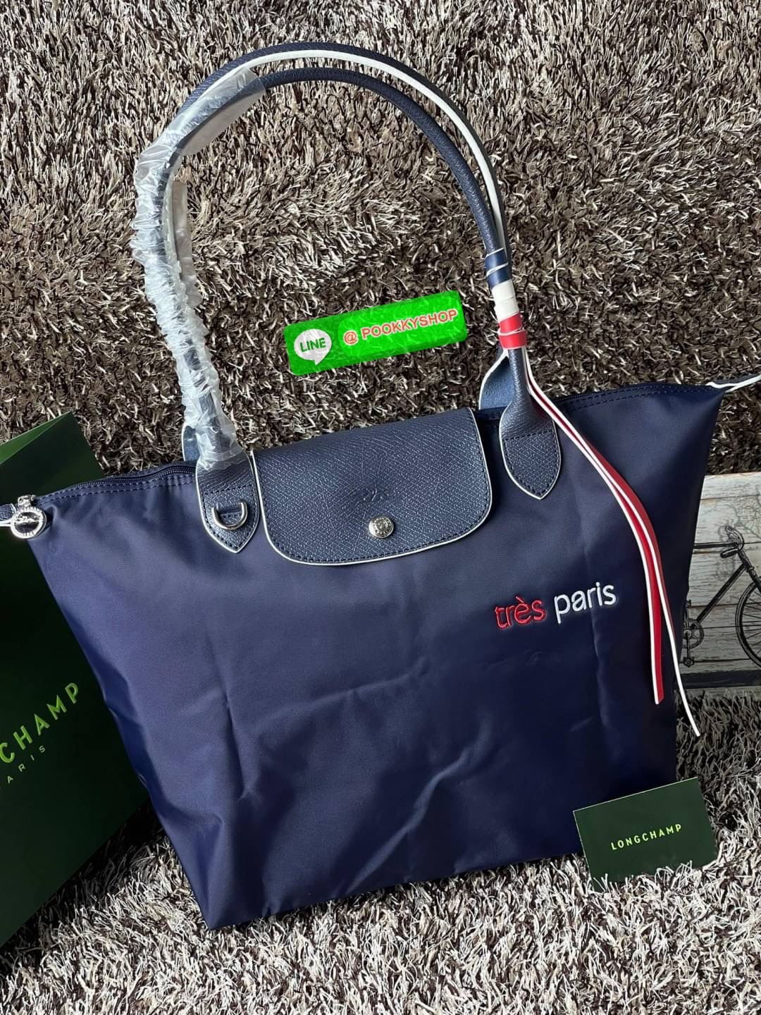 💕LONGCHAMP LE PLIAGE TRES PARIS SHOULDER BAG กระเป๋าโท้ทใบนี้ดึงดูดใจคุณด้วยรูปทรงมินิมอลและปริมาตรที่เพียงพอซึ่งสามารถเก็บเอกสารหรือแล็ปท็อปทั้งหมดของคุณได้อย่างง่ายดาย สายคล้องไหล่มีความยาวช่วยให้คุณสะพายได้อย่างสบาย ขณะที่การปิดด้วยซิปช่วยให้มั