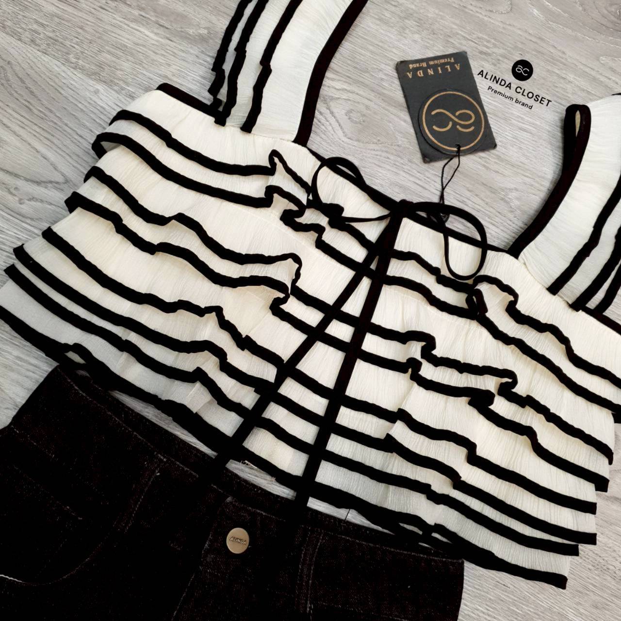 ชุดเซทแฟชั่น ชุดเซ็ทเสื้อสายเดี่ยวทรงครอปสีครีมตัดขอบสีดำ แต่งระบายคู่ที่สายเสื้อ