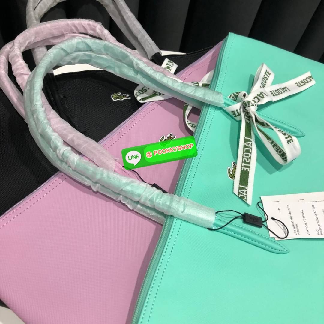 ลาคอส Classic Tote Bag กระเป๋าสะพายทรงช้อปปิ้งหลากสีรุ่นยอดนิยมด้านหน้าประดับโลโก้จระเข้สัญลักษณ์แบรนด์ ภายในกว้างจุได้เยอะ เปิดปิดด้วยซิปสะดวกใช้ มี1 ช่องซิปเล็ก หัวซิปปั้มเเบรนด์ วัสดุกันน้ำ ขนาดกำลังดี ใส่หนังสือ เอกสารA4 ของใช้ได้เยอะ สวยทุกสีค่ะ