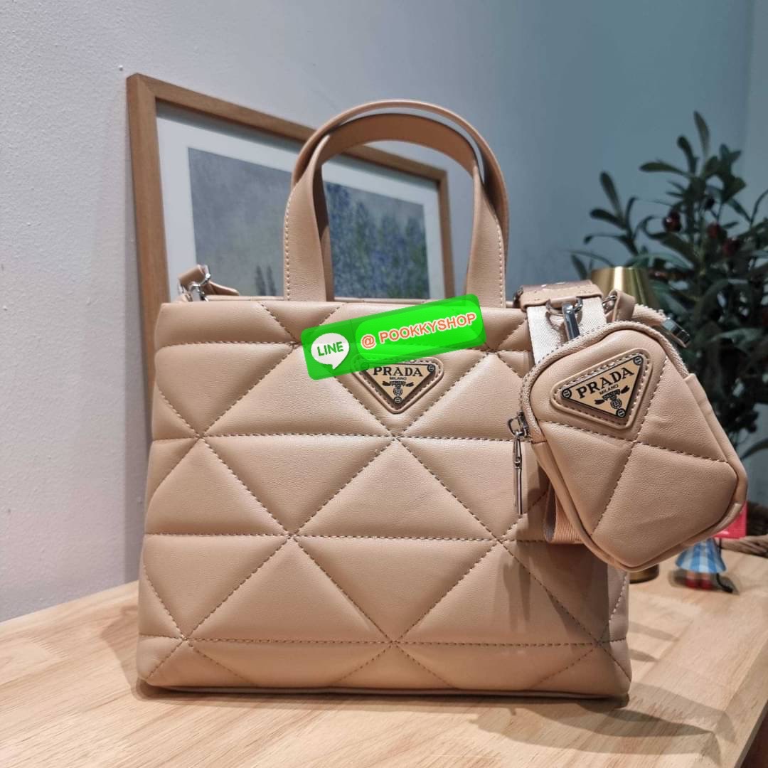 PRADA LEATHER PADDED BAG ใหม่ล่าสุด กับคอลเลคชั่นที่ทำออกมาตอบโจทย์ได้ทุกไลฟ์สไตล์ และเป็นยูนิเซ็กส์ กับกระเป๋าทรงโท้ท ขนาดกำลังดี วัสดุหนังแท้ ตัดเย็บเดินเส้นลายตาราง ปากกระเป๋ามีซิปเปิดปิด ภายในเป็นช่องโล่ง มีช่องแยกให้ มาพร้อมสะพายข้างและใบลูก ให้ได้สน