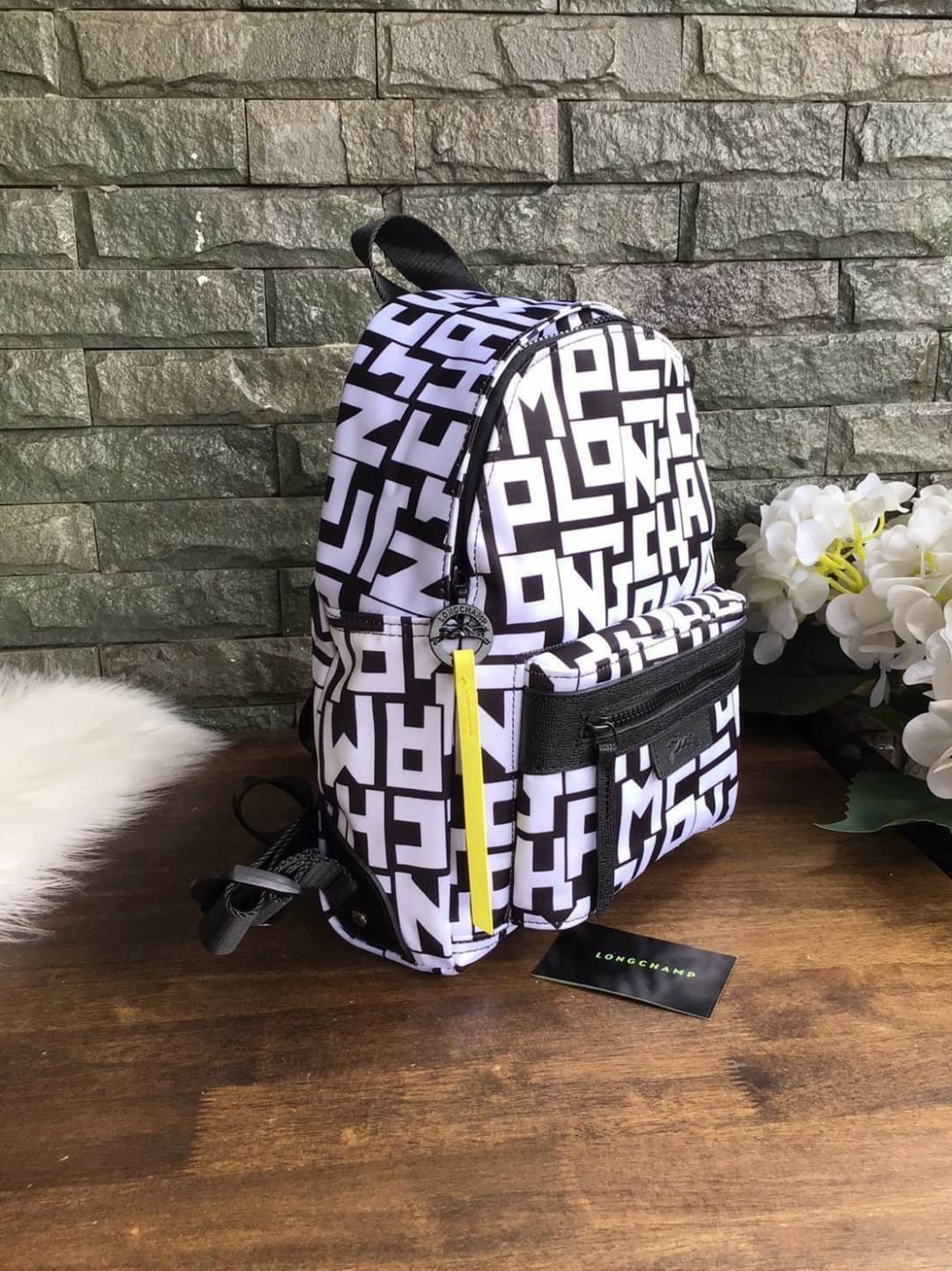 LONGCHAMP LE PLIAGE LGP BACKPACK รายละเอียด • วัสดุ: ผ้าใบ • อะไหล่: นิกเกิล • ตัวกระเป๋า: ผ้าใบโพลีอะไมด์เคลือบด้านใน • ตกแต่ง: หนังวัว รายละเอียดภายนอก • การปิด: ด้วยซิป • สายสะพาย: เลื่อนปรับระดับได้ • ช่อง: 1 ช่องซิป ภายใน • ช่องใส่ของ: 1 ช่อง ช่องด้า