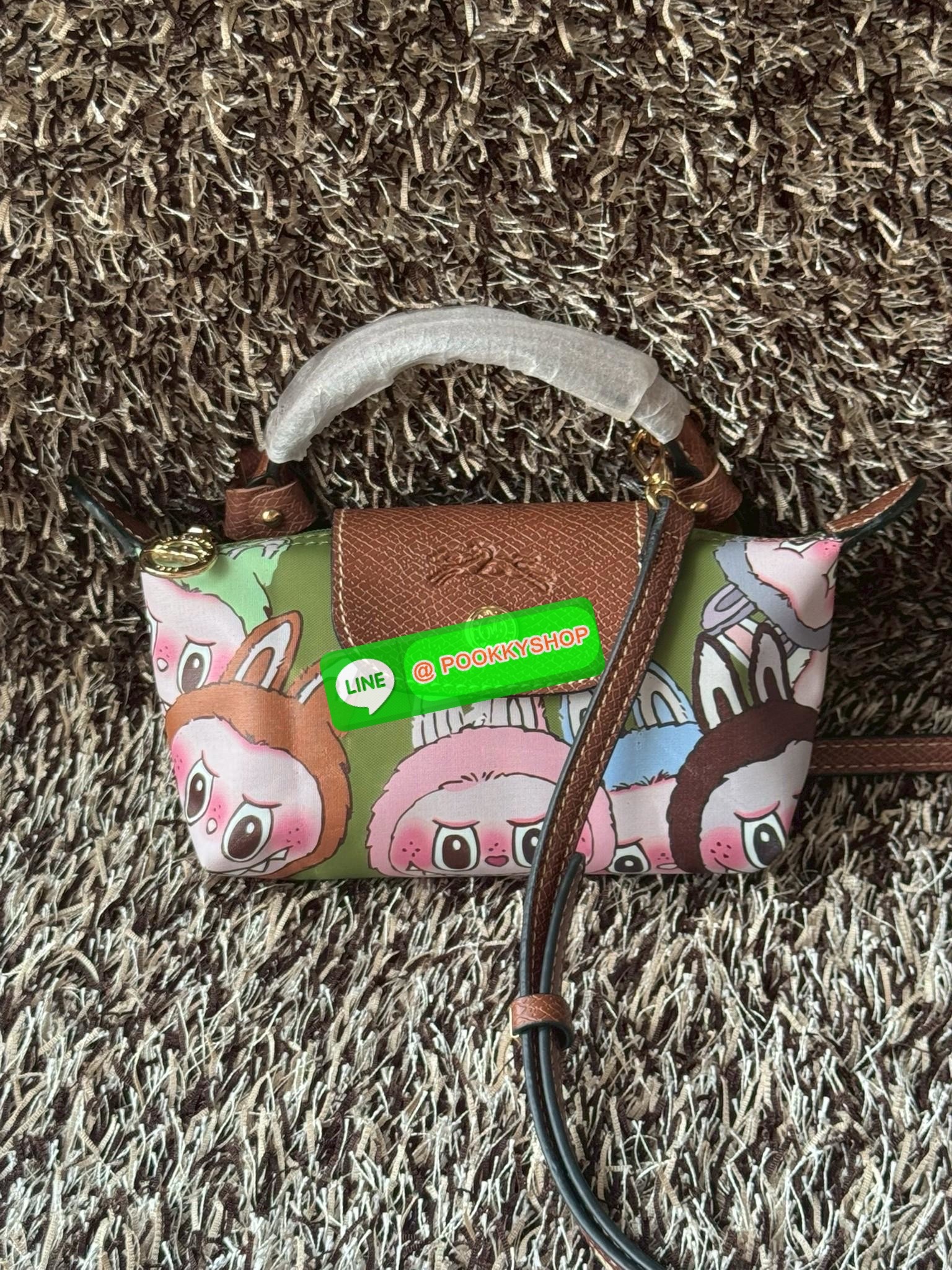 LONGCHAMP LE PLIAGE ORIGINAL X Labubu Pouch with handle เป็นการร่วมงานกัระหว่างแบรนด์ และยังกระเป๋าถือขนาดมินิทรงpouch ที่ด้านหน้ามีลวดลายน้องลาบูบู้ในแบบต่างๆ เปิดปิดระบบสองชั้น ได้ว่าของด้านในมีความปลอดภัย เหมาะอย่างยิ่งสำหรับสาวๆที่ชอบกระเป๋าขนาดมินิไซ