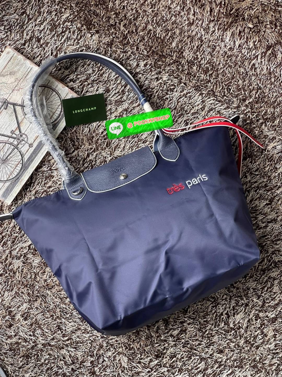 💕LONGCHAMP LE PLIAGE TRES PARIS SHOULDER BAG กระเป๋าโท้ทใบนี้ดึงดูดใจคุณด้วยรูปทรงมินิมอลและปริมาตรที่เพียงพอซึ่งสามารถเก็บเอกสารหรือแล็ปท็อปทั้งหมดของคุณได้อย่างง่ายดาย สายคล้องไหล่มีความยาวช่วยให้คุณสะพายได้อย่างสบาย ขณะที่การปิดด้วยซิปช่วยให้มั