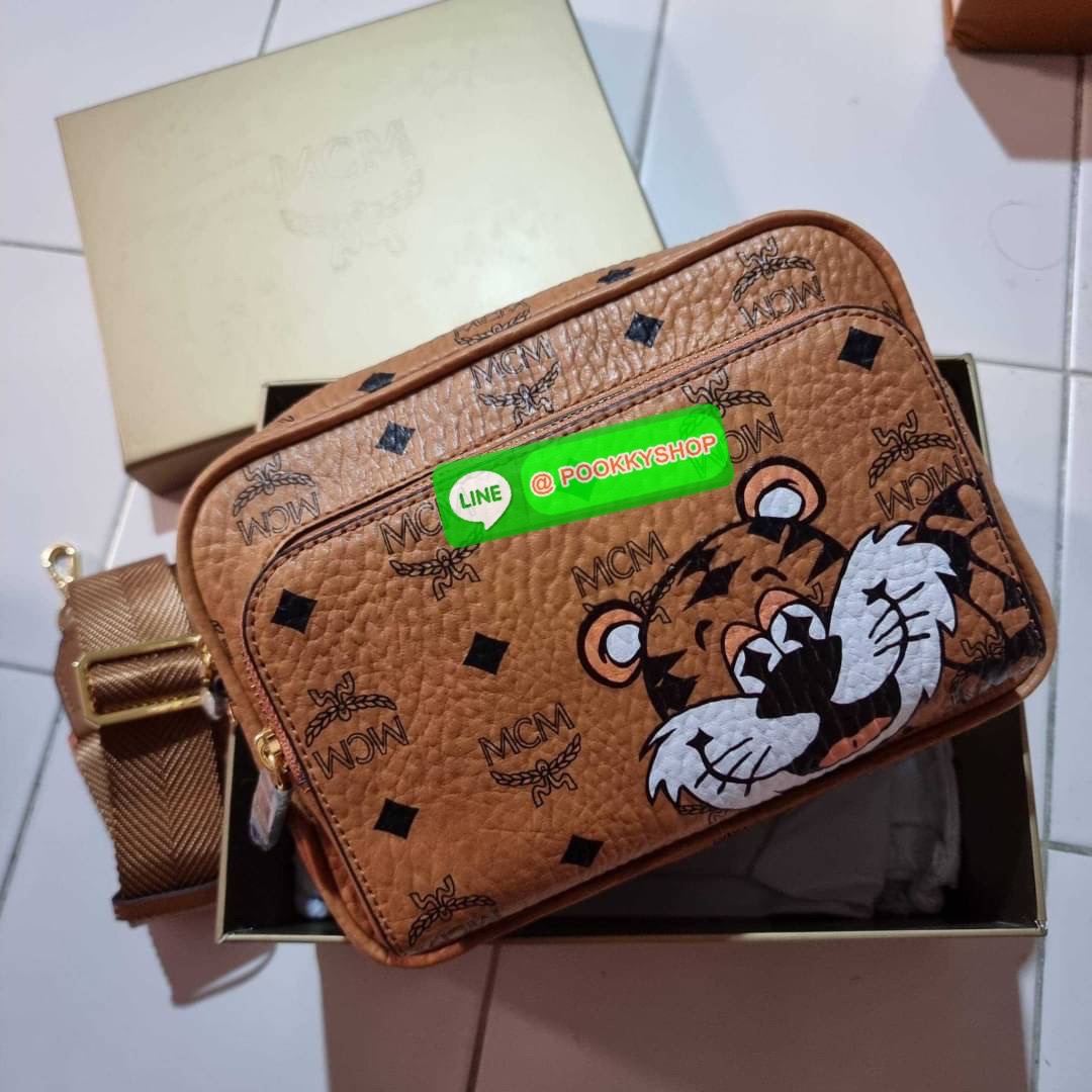 MCM KLASSIK CROSSBODY IN NEW YEAR TIGER VISETOS ใหม่ล่าสุด คอลเลคชั่นรับปีเสือ ของมันต้องมี กระเป๋าสะพายข้างทรงครอสบอดี้ โดดเด่นด้วยลายพริ้นท์น้องเสือคมสวย รุ่นนี้หนุ่มๆหรือสาวๆก็สะพายได้น้า ขนาดกำลังดี วัสดุหนังแคนวาสคุณภาพดี มีช่องหลัก 2 ช่อง เปิด-ปิดด้