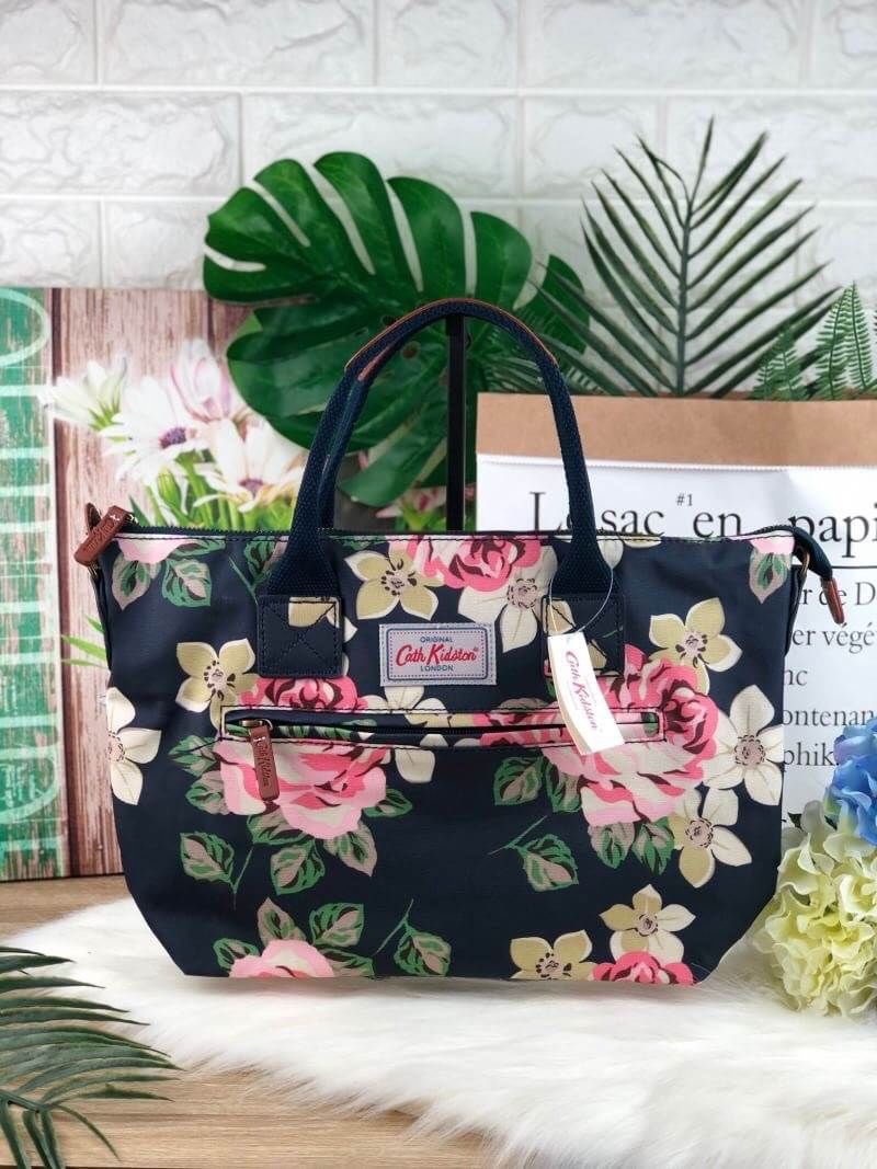 CATH KIDSTON HANDBAG กระเป๋าถือ/สะพายทรงสวย ด้านหน้ามีช่องซิปใส่ของจุกจิกได้ มีหมุดรองฐาน 4 มุม หูหิ้วมีหนังรองมือ เปิดปิดด้วยซิปบน ด้านในกว้างจุของได้เยอะ มีช่องซิปเล็ก 1 ช่อง มาพร้อมสายสะพายยาวถอดและปรับสายได้ รุ่นนี้น้ำหนักเบา ใช้งานง่ายได้หลายโอกาส มี