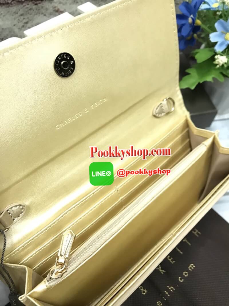 ถุงผ้าแบรนด์+สายโซ่) CHARLES & KEITH BOW DETAIL LONG WALLET กระเป๋าสตางค์ยาวหนังลายคาร์เวียร์ ด้านหน้าประดับด้วยโบว์อะไหล่สีทอง เปิด-ปิดด้วยกระดุมแม่เหล็ก ภายในมีช่องซิปใส่เหรียญ บัตร และช่องธนบัตร มาพร้อมสายโซ่ร้อยหนัง สามารถถอดออกได้ ความยาวสาย40cm คล้อ