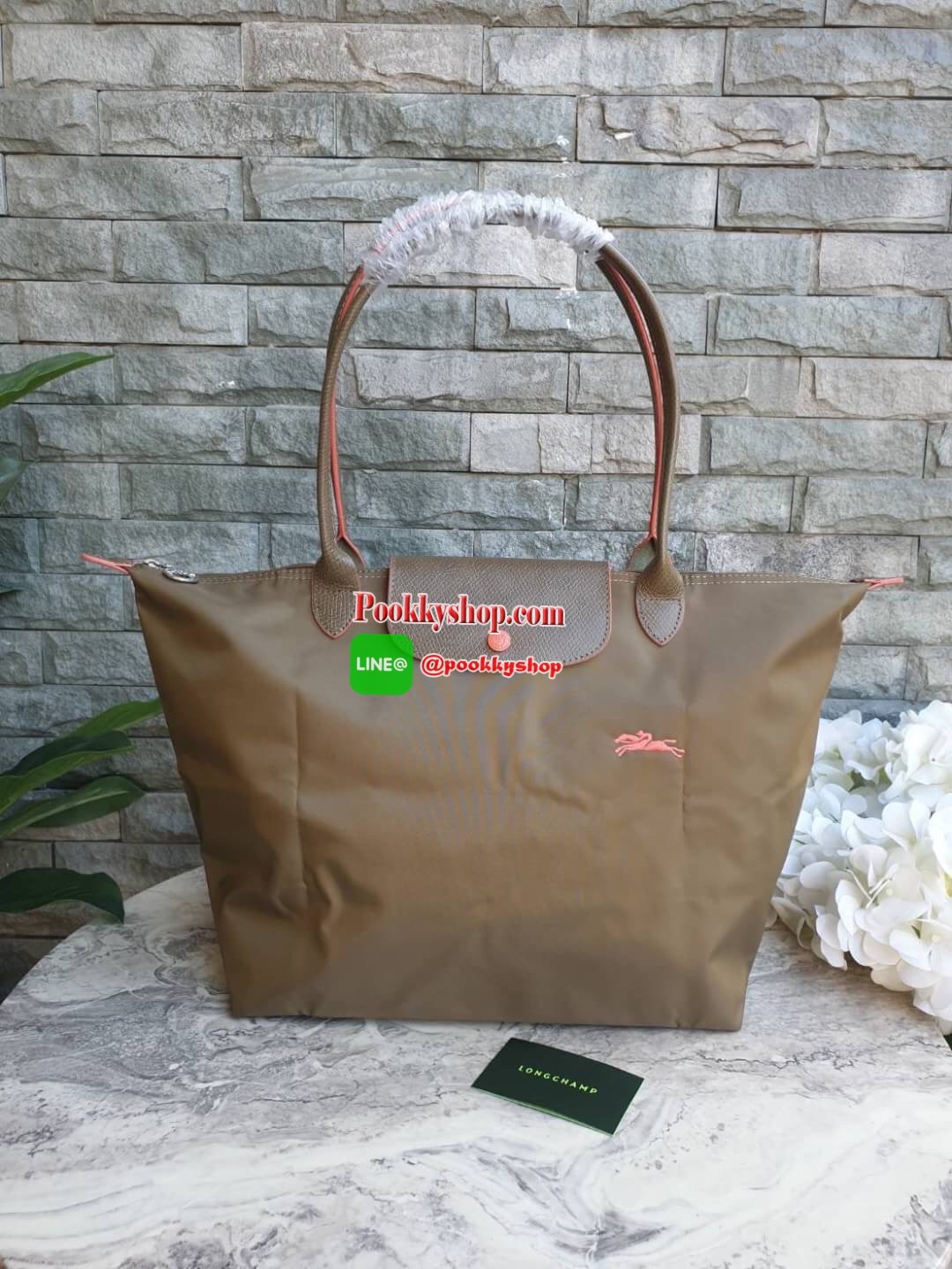 Longchamp Le Pliage Club Tote Bag Size L หูยาว วัสดุเนื้อผ้า Nylon Canvas เคลือบกันนำ้ ตัดด้วยหนังแท้ที่มีน้ำหนักเบา ดีไซน์เรียบง่ายแต่เต็มไปด้วยความคลาสสิก จนเป็นที่ชื่นชอบไปทั่วโลก Longchamp ปรับโฉม LE PLIAGE ด้วยการปักลายรูปม้า-ตราสัญลักษณ์ของแบรนด์บนผ