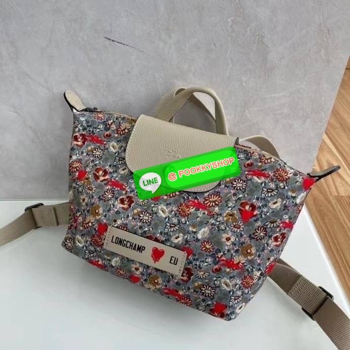 New Arrival Longchamp X Eu Backpack กระเป๋าเป้สะพายหลังลายดอกๆไม้ วัสดุผ้าฝ้าย อะไหล่สีดำ กระเป๋าเป้แบบลำลองสำหรับสตรีซึ่งนำรูปทรงอันเป็นเอกลักษณ์ของ Le Pliage มาปรับใช้กับทุกสถานการณ์ อุปกรณ์เสริมที่ใช้งานได้จริงนี้มีสายรัดปรับระดับได้และที่จับช่วยให้ สะ