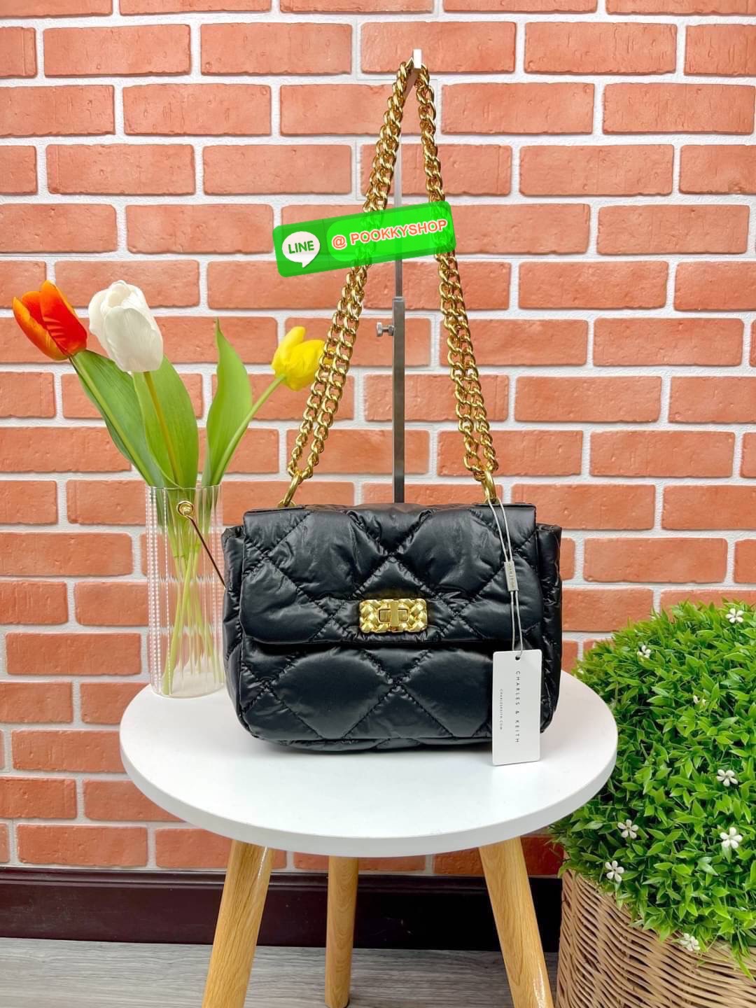 Charles & Keith Paffuto Padded Shoulder Bag มาเพิ่มสีสันให้กับสไตล์ในวันพักผ่อนสบายๆของคุณให้ดูสนุกขึ้น ด้วยกระเป๋าสะพายไหล่ขนาดกลางที่โดดเด่นด้วยหนังเย็บบุลายตาราง โก้หรูด้วยดีไซน์ตัวล็อคโลหะที่เข้ากับสายสะพายโซ่ เปิดปิดแบบตัวหมุนล็อก ด้านในจุของได้เยอะ