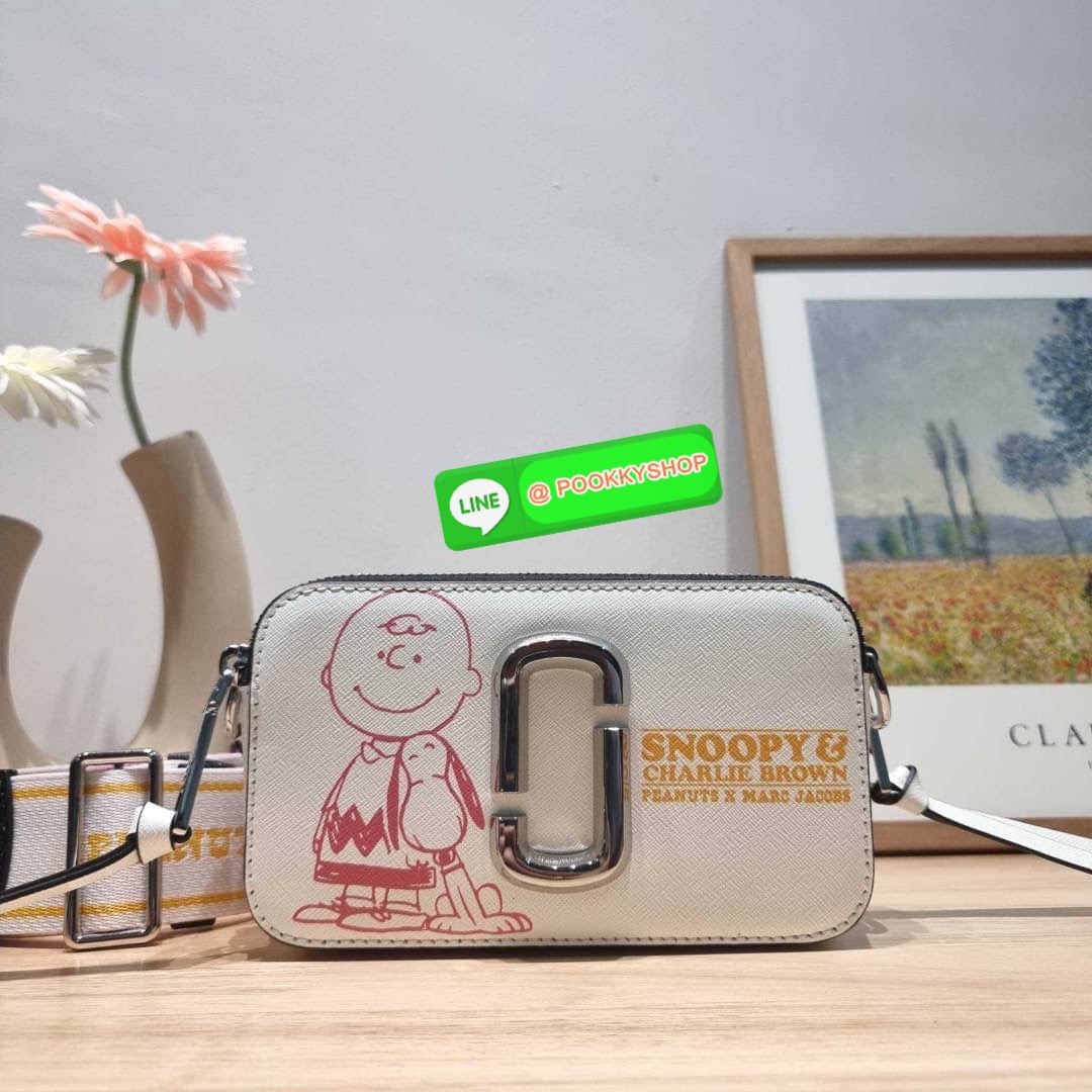 PEANUTS × MARC JACOBS THE SNAPSHOT CROSSBODY BAG คอลเลคชั่นแสนคิวท์ ที่ยกขบวนเหล่าซุปตาร์การ์ตูนมาให้แบบจัดเต็ม กับไอเท็มยอดฮิตที่โดดเด่นเป็นเอกลักษณ์ กระเป๋าสะพายข้างสุดปัง ดีไซน์ลายพรินท์แก๊งค์การ์ตูนสุดฮอต เรียกได้ว่าไม่ซ้ำใคร!! วัสดุหนังวัว สวยอยู่ทรง