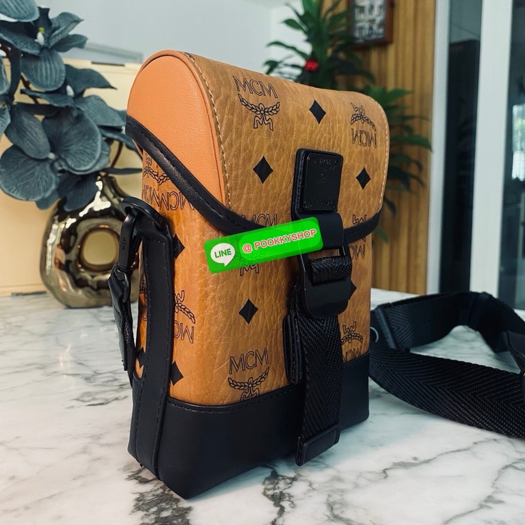 MCM Small Aren N/S Crossbody in Visetos Cognac คอลใหม่เอาใจหนุ่มๆ สั่งก่อนหล่อก่อนน้าา!! กับกระเป๋าสะพายข้างสุดชิค ที่ดูดีมีเสน่ห์มากๆ เห็นแล้วก็ต้องหลงแน่นอน รูปทรงกะทัดรัด สะพายแล้วคล่องตัว เปิด-ปิดด้วยกระดุมแม่เหล็ก ภายในเป็นช่องโล่ง ใส่โทรศัพท์ได้ทุกร
