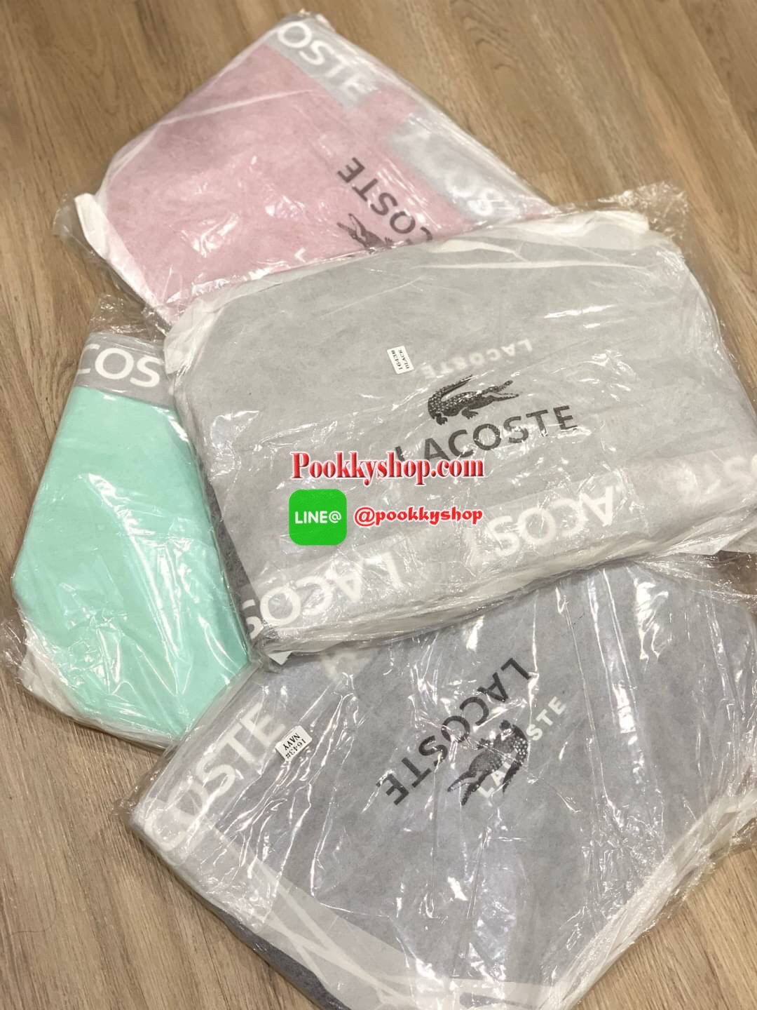 ลาคอส Shopping Bag กระเป๋าถือทรงช้อปปิ้งขนาดใหญ่ ที่ใส่สัมภาระได้รวมถึงใส่เอกสารขนาด A4 ได้ วัสดุ PVC กันน้ำ ดูแลรักษาง่าย ตัดขอบด้วยแถบโลโก้สีเทา ด้านหน้าสกรีนโลโก้และประดับจรเข้อันเป็นสัญลักษณ์ เปิดปิดด้วยซิปเดียว ภายในสกรีนโลโก้แบรนด์ ใบใหญ่สวยโดดเด่