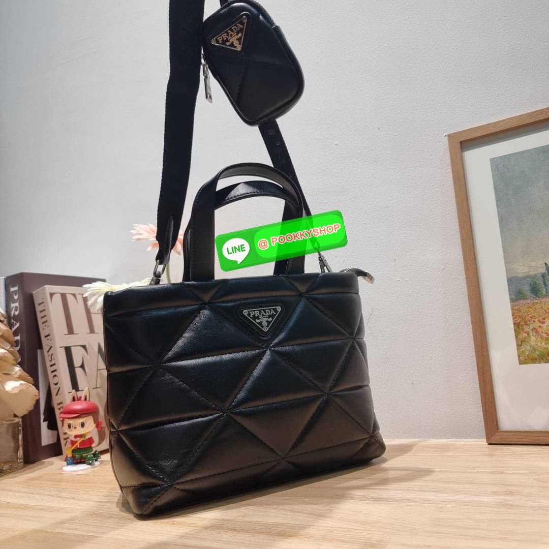 PRADA LEATHER PADDED BAG ใหม่ล่าสุด กับคอลเลคชั่นที่ทำออกมาตอบโจทย์ได้ทุกไลฟ์สไตล์ และเป็นยูนิเซ็กส์ กับกระเป๋าทรงโท้ท ขนาดกำลังดี วัสดุหนังแท้ ตัดเย็บเดินเส้นลายตาราง ปากกระเป๋ามีซิปเปิดปิด ภายในเป็นช่องโล่ง มีช่องแยกให้ มาพร้อมสะพายข้างและใบลูก ให้ได้สน