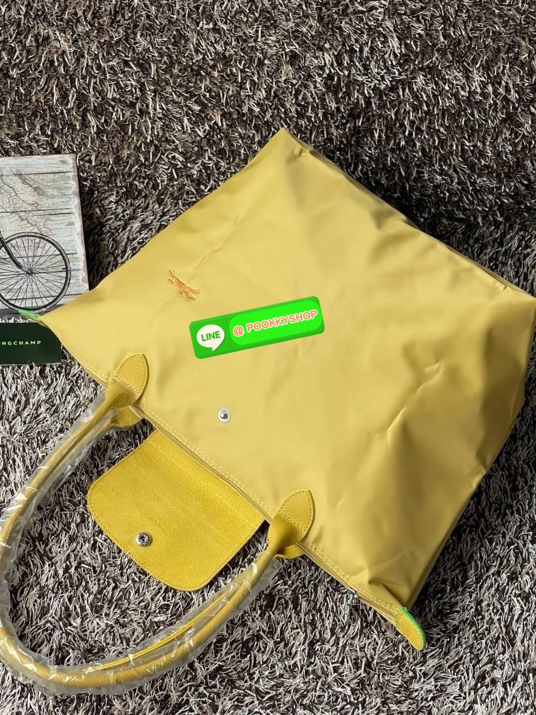 LONGCHAMP LE PLIAGE GREEN Shoulder bag L กระเป๋าโท้ทใบนี้ดึงดูดใจคุณด้วยรูปทรงมินิมอลและปริมาตรที่เพียงพอซึ่งสามารถเก็บเอกสารหรือแล็ปท็อปทั้งหมดของคุณได้อย่างง่ายดาย ด้ามยาวช่วยให้คุณสวมใส่ได้อย่างสบายบนไหล่ ขณะที่การปิดด้วยซิปช่วยให้มั่นใจได้ว่าสิ่งของทั