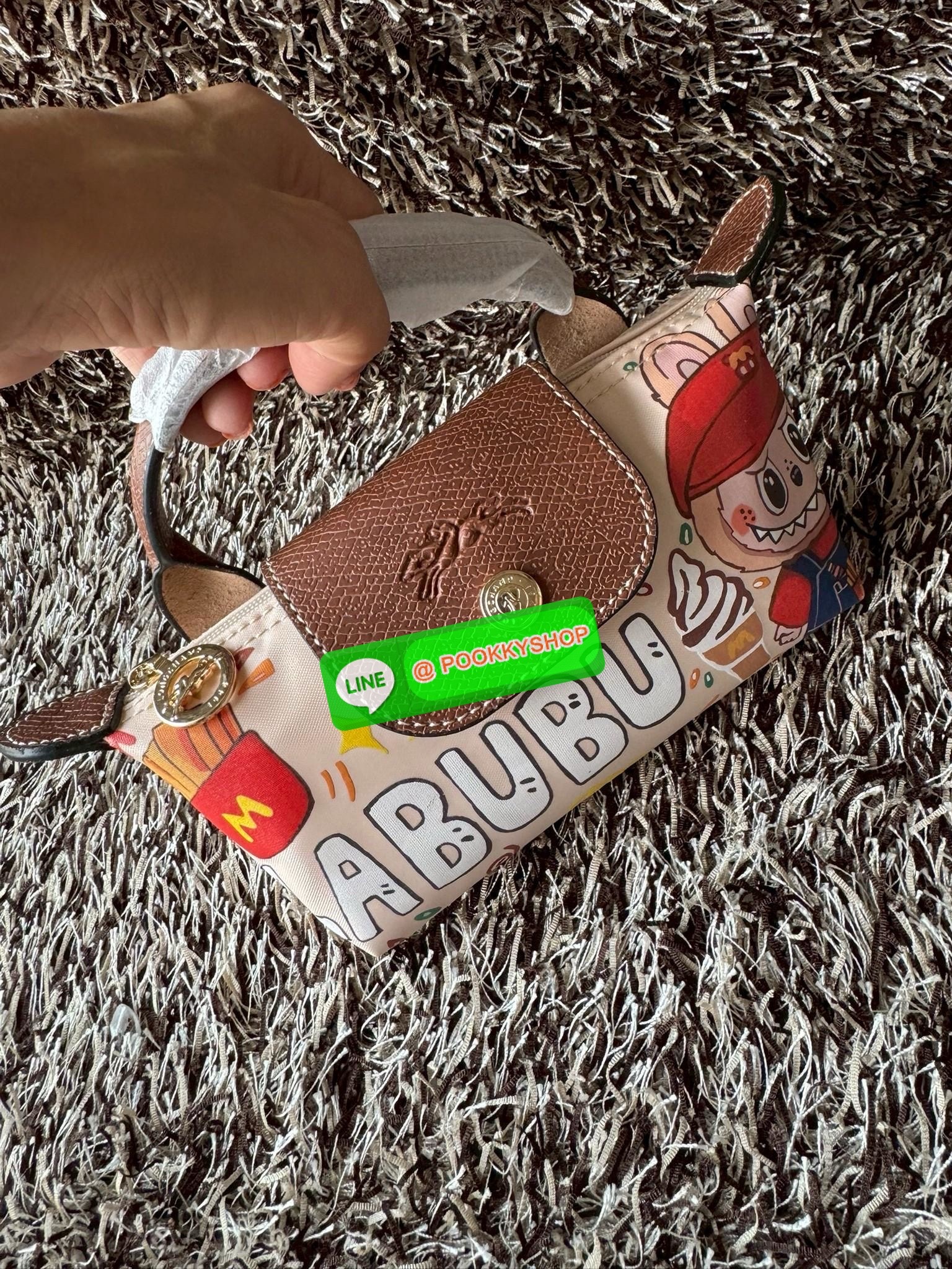 LONGCHAMP LE PLIAGE ORIGINAL X Labubu Pouch with handle เป็นการร่วมงานกัระหว่างแบรนด์ และยังกระเป๋าถือขนาดมินิทรงpouch ที่ด้านหน้ามีลวดลายน้องลาบูบู้ในแบบต่างๆ เปิดปิดระบบสองชั้น ได้ว่าของด้านในมีความปลอดภัย เหมาะอย่างยิ่งสำหรับสาวๆที่ชอบกระเป๋าขนาดมินิไซ