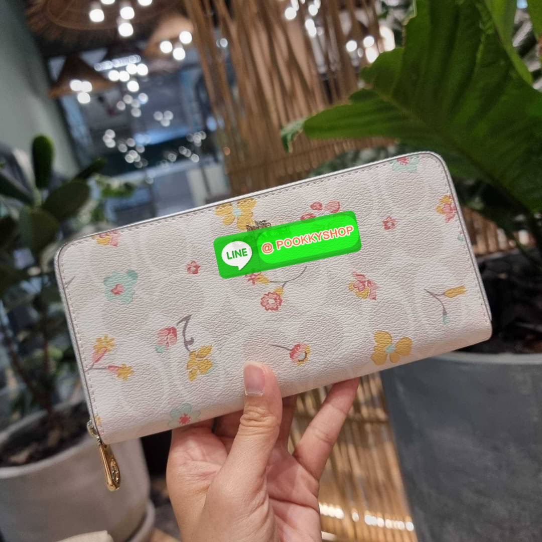 COACH C8695 LONG ZIP AROUND WALLET IN SIGNATURE CANVAS WITH MYSTICAL FLORAL PRINT พร้อมเสิร์ฟความหรู กับคอลใหม่ล่าสุด กระเป๋าสตางค์ใบยาวกึ่งคล้องมือ มาในดีไซน์ผู้ดี เรียบหรู ถือใช้แล้วขับผิวมาก ลวดลายดอกไม้คละเคล้าสวยงาม วัสดุหนังแคนวาสเคลือบลาย มาพร้อมสา