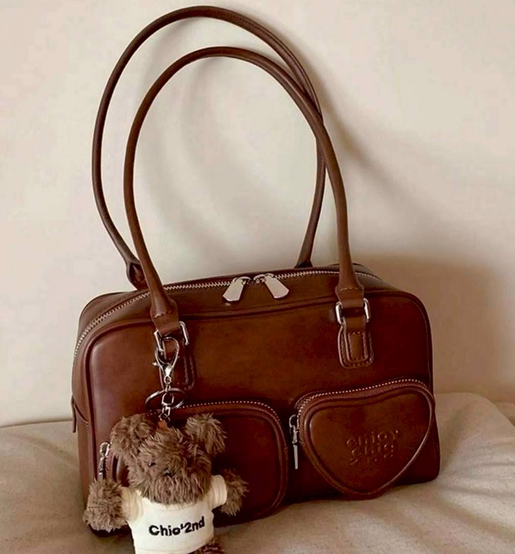 กระเป๋าหนังอย่างดี สีน้ำตาล ปั้มอักษร enjoy มีช่องซิปหน้า 2ช่อง แถมพวงกุญแจตุ๊กตาขนนุ่มน่ารัก หูกระเป๋ายาวคล้องไหล่ คล้องแขนหรือถือได้หมด งานเกรดแพง สวยตรงปก