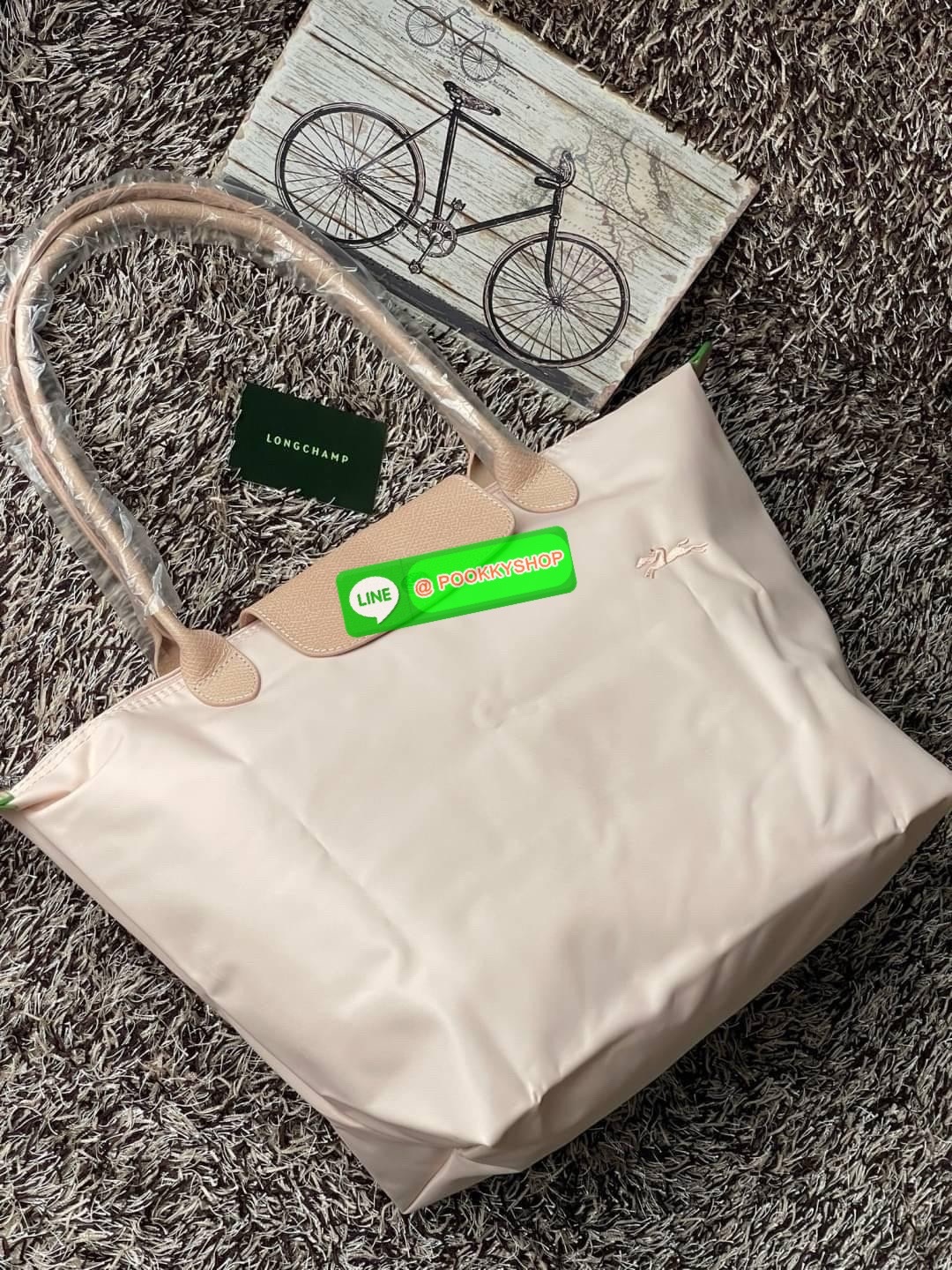 LONGCHAMP LE PLIAGE GREEN Shoulder bag L กระเป๋าโท้ทใบนี้ดึงดูดใจคุณด้วยรูปทรงมินิมอลและปริมาตรที่เพียงพอซึ่งสามารถเก็บเอกสารหรือแล็ปท็อปทั้งหมดของคุณได้อย่างง่ายดาย ด้ามยาวช่วยให้คุณสวมใส่ได้อย่างสบายบนไหล่ ขณะที่การปิดด้วยซิปช่วยให้มั่นใจได้ว่าสิ่งของทั