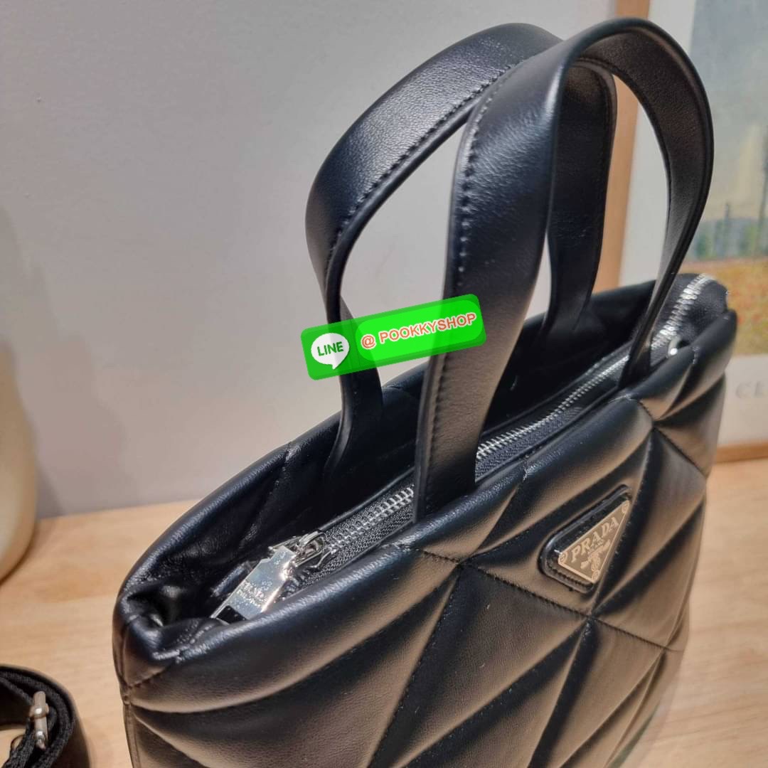 PRADA LEATHER PADDED BAG ใหม่ล่าสุด กับคอลเลคชั่นที่ทำออกมาตอบโจทย์ได้ทุกไลฟ์สไตล์ และเป็นยูนิเซ็กส์ กับกระเป๋าทรงโท้ท ขนาดกำลังดี วัสดุหนังแท้ ตัดเย็บเดินเส้นลายตาราง ปากกระเป๋ามีซิปเปิดปิด ภายในเป็นช่องโล่ง มีช่องแยกให้ มาพร้อมสะพายข้างและใบลูก ให้ได้สน