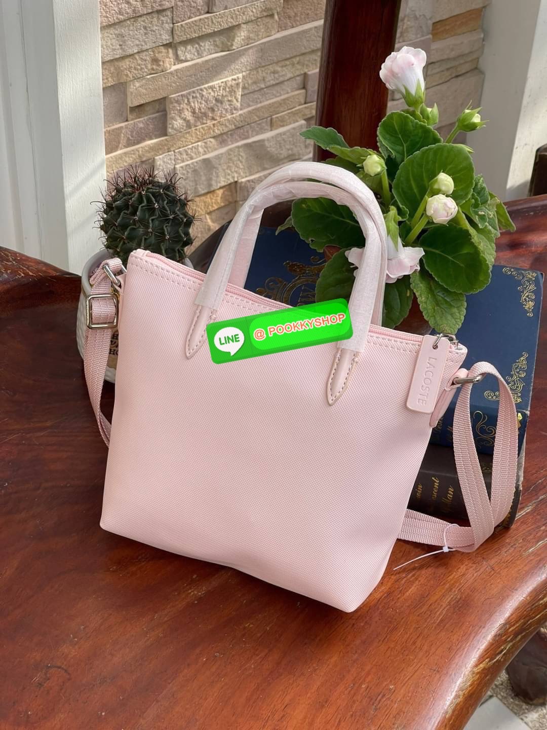 ลาคอส Women's L.12.12 Concept Petit Piqué Zip Tote กระเป๋าสะพายข้างทรง mini tote วัสดุ pvc100% เปิดปิดด้วยซิปเดียวด้านบนสะดวกใช้งาน ใส่มือถือได้ทุกรุ่น ด้านหน้ามีดีเทลโลโก้ปักดูโดดเด่น สายของกระเป๋ารุ่นนี้สามารถปรับความยาวได้ฟรีไซส์ เลือกสะพายได้ ไ