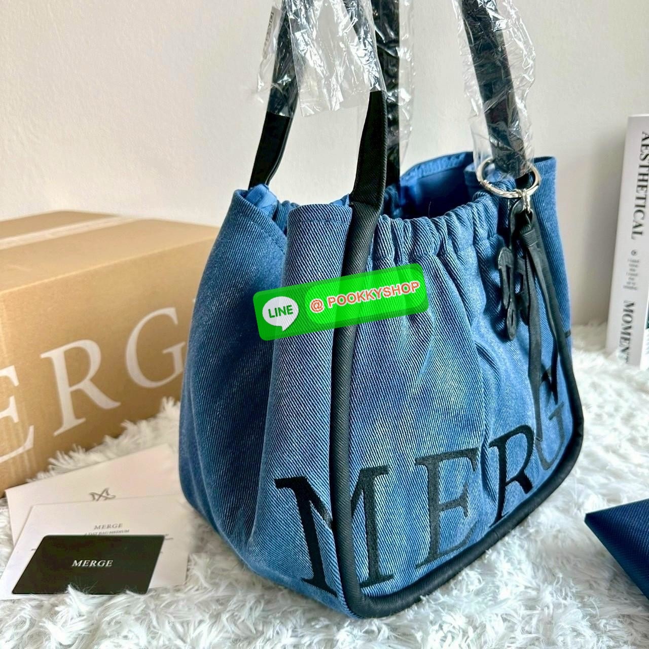Merg A Day Bag Medium เฉดสีใหม่ 2 สี Smoky Denim กระเป๋ายีนส์ทรงโท้ท ดีไซน์เรียบเท่แต่มีลูกเล่นด้วยเชือกรูด เปิด-ปิดสะดวก ใบใหญ่จุของได้เยอะ มาพร้อมช่องด้านในและตัวล็อกสายคล้องกุญแจเพิ่มความปลอดภัย เหมาะกับสาวสายชิคที่ชอบสไตล์ลำลองแต่ยังดูมีคลาส ขนาดกระเป