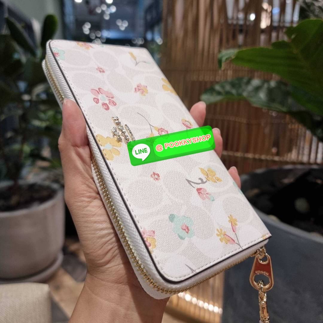 COACH C8695 LONG ZIP AROUND WALLET IN SIGNATURE CANVAS WITH MYSTICAL FLORAL PRINT พร้อมเสิร์ฟความหรู กับคอลใหม่ล่าสุด กระเป๋าสตางค์ใบยาวกึ่งคล้องมือ มาในดีไซน์ผู้ดี เรียบหรู ถือใช้แล้วขับผิวมาก ลวดลายดอกไม้คละเคล้าสวยงาม วัสดุหนังแคนวาสเคลือบลาย มาพร้อมสา