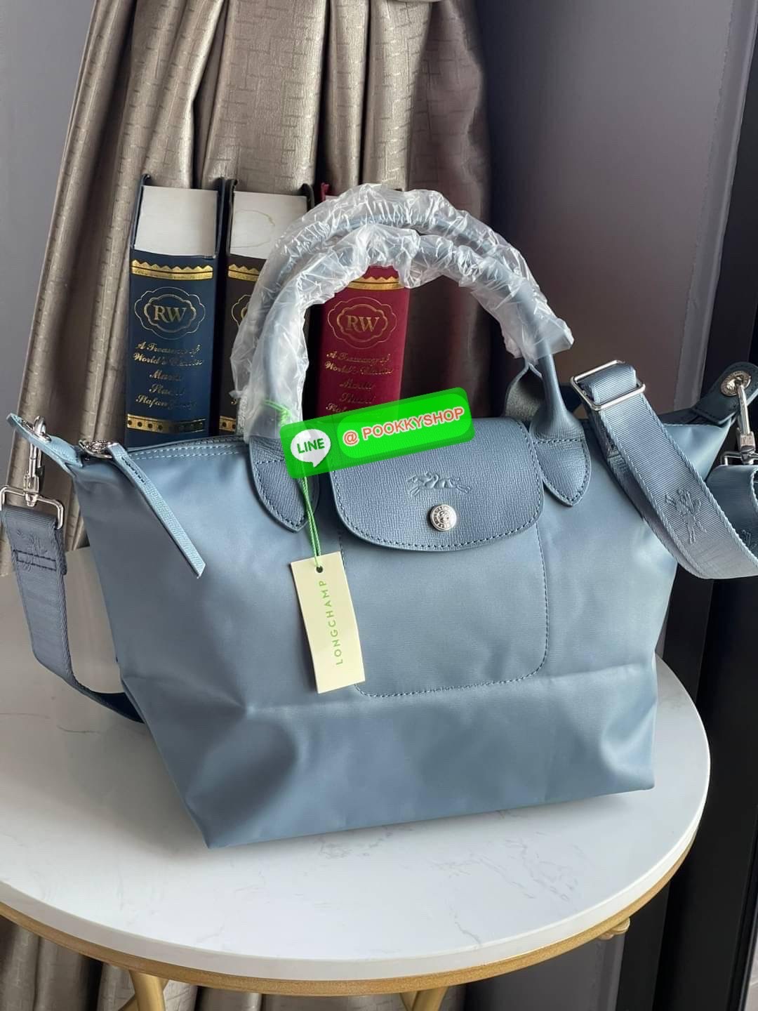 💕Longchamp LE PLIAGE NÉO TOP HANDLE BAG (small size) อีกหนึ่งรุ่นยอดนิยม ที่สาวๆ ต้องมีไว้เก็บไว้สักใบ กระเป๋าโท้ทใบนี้ มาพร้อมกับสีที่มีสไตล์เรียบง่าย มีสายสะพายยาวปรับสั้นยาวได้ช่วยให้คุณสามารถสะพายไหล่ได้อย่างสบาย ในตัวสายปักโลโก้อันเป็นสัญลักษ
