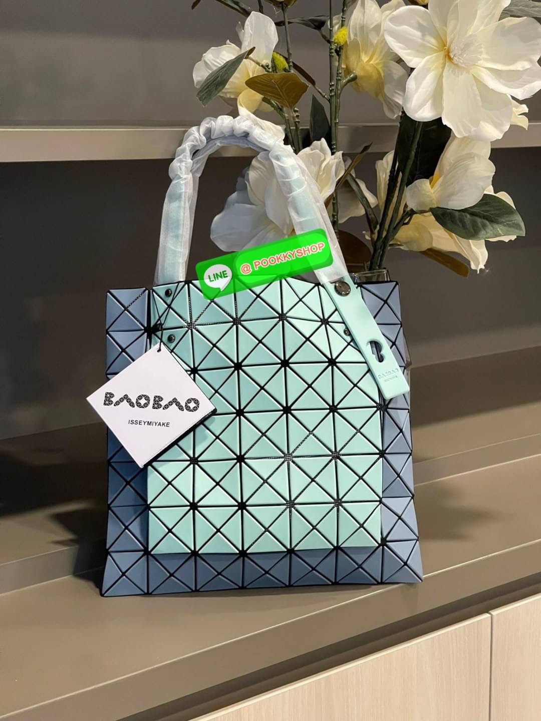 Baobao Issey Miyake Prism Kangaroo tote bag กระเป๋าถือทรงโท้ทที่ประดิษฐ์ขึ้นอย่างเชี่ยวชาญในญี่ปุ่น มาพร้อมแผงเรขาคณิตสำหรับการออกแบบที่ได้รับแรงบันดาลใจจากกระดาษพับ ซิลลูเอทอันเป็นเอกลักษณ์นี้ปิดท้ายด้วยสายรัดแบบอสมมาตร มีการพัฒนาโครงสร้างทรงสามเหลี่ยมเพ