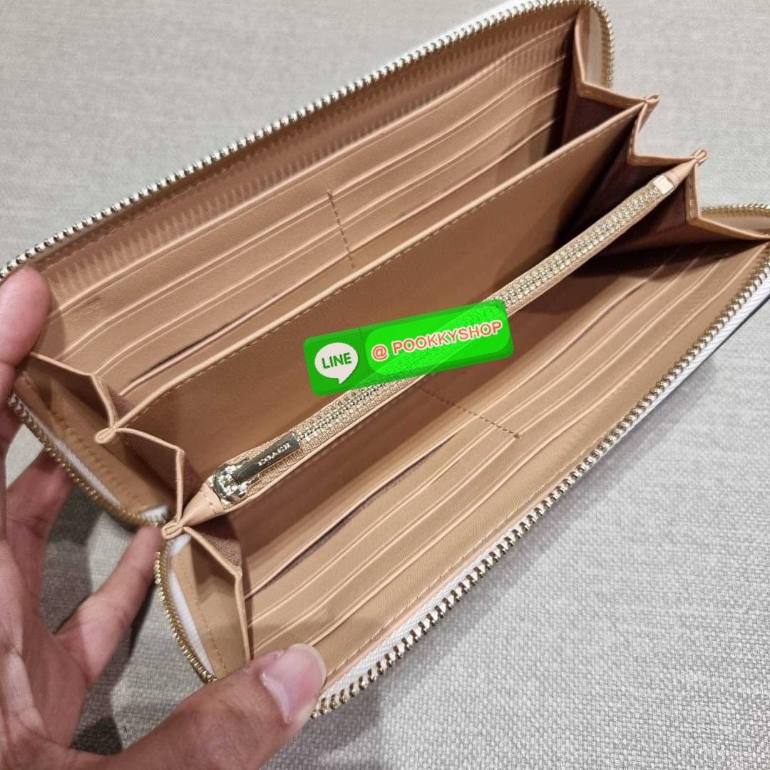 COACH C8695 LONG ZIP AROUND WALLET IN SIGNATURE CANVAS WITH MYSTICAL FLORAL PRINT พร้อมเสิร์ฟความหรู กับคอลใหม่ล่าสุด กระเป๋าสตางค์ใบยาวกึ่งคล้องมือ มาในดีไซน์ผู้ดี เรียบหรู ถือใช้แล้วขับผิวมาก ลวดลายดอกไม้คละเคล้าสวยงาม วัสดุหนังแคนวาสเคลือบลาย มาพร้อมสา