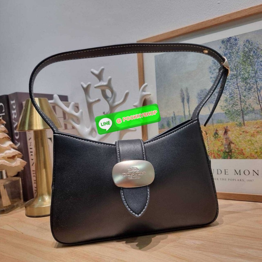 COACH CR533 ELIZA SHOULDER BAG 🔅 Details ใหม่ล่าสุด กระเป๋าสะพายไหล่ทรงโฮโบสุดหรู ดีไซน์โลโก้แบบใหม่และหรูหรายิ่งขึ้น คงความคลาสสิคและวินเทจ เปิด-ปิดด้วยสายคาดแบบกระดุมแม่เหล็ก ภายในเป็นช่องโล่ง แบ่งสัดส่วนไว้อย่างดี มีทั้งช่องใส่บัตร และช่องซิป ส