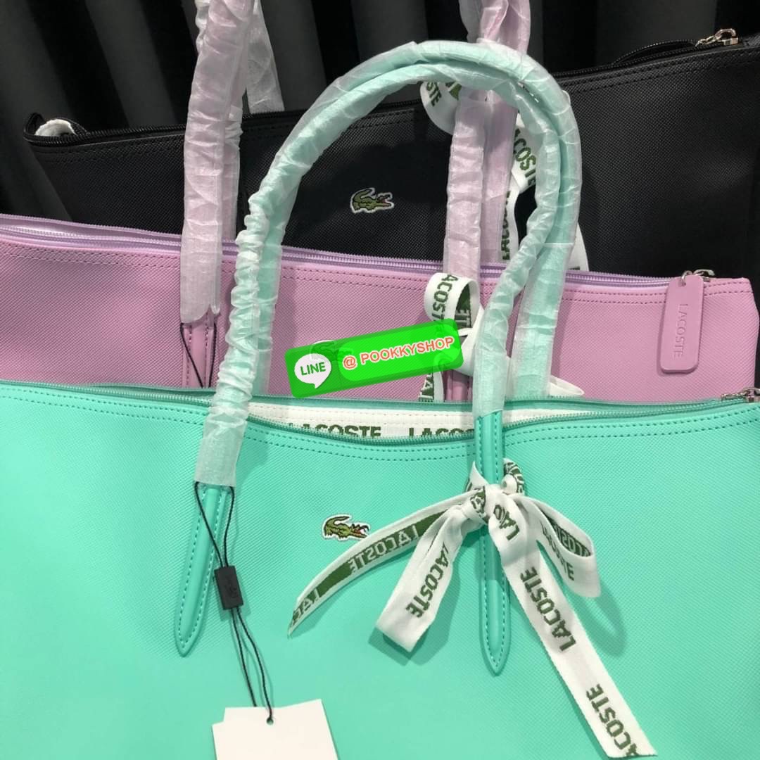 ลาคอส Classic Tote Bag กระเป๋าสะพายทรงช้อปปิ้งหลากสีรุ่นยอดนิยมด้านหน้าประดับโลโก้จระเข้สัญลักษณ์แบรนด์ ภายในกว้างจุได้เยอะ เปิดปิดด้วยซิปสะดวกใช้ มี1 ช่องซิปเล็ก หัวซิปปั้มเเบรนด์ วัสดุกันน้ำ ขนาดกำลังดี ใส่หนังสือ เอกสารA4 ของใช้ได้เยอะ สวยทุกสีค่ะ