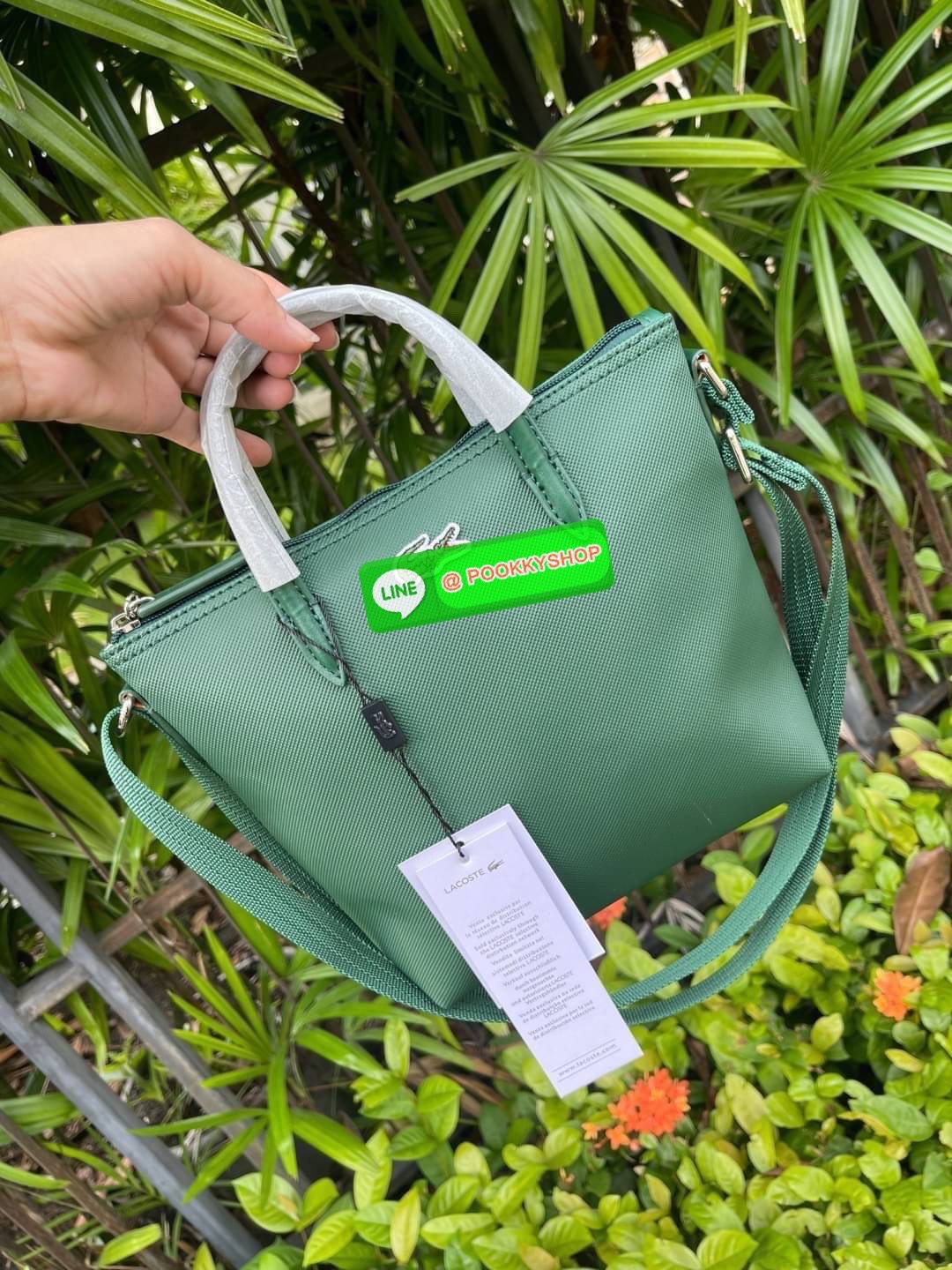 ลาคอส Women's L.12.12 Concept Petit Piqué Zip Tote กระเป๋าสะพายข้างทรง mini tote วัสดุ pvc100% เปิดปิดด้วยซิปเดียวด้านบนสะดวกใช้งาน ใส่มือถือได้ทุกรุ่น ด้านหน้ามีดีเทลโลโก้ปักดูโดดเด่น สายของกระเป๋ารุ่นนี้สามารถปรับความยาวได้ฟรีไซส์ เลือกสะพายได้ ไ