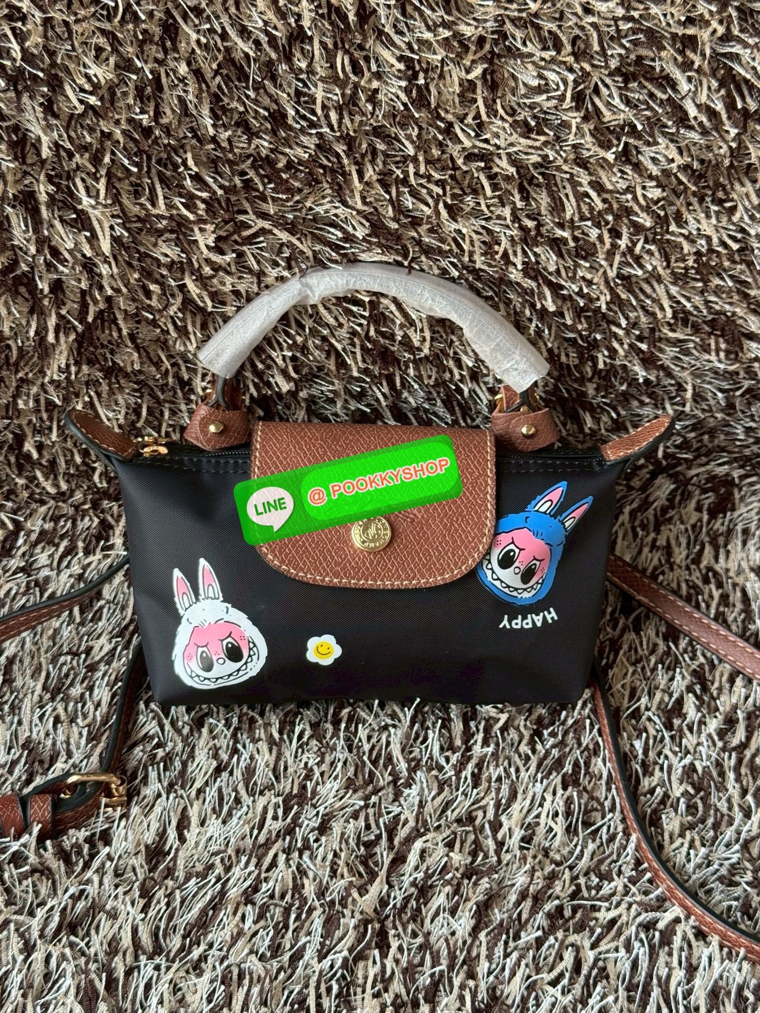 LONGCHAMP LE PLIAGE ORIGINAL X Labubu Pouch with handle เป็นการร่วมงานกัระหว่างแบรนด์ และยังกระเป๋าถือขนาดมินิทรงpouch ที่ด้านหน้ามีลวดลายน้องลาบูบู้ในแบบต่างๆ เปิดปิดระบบสองชั้น ได้ว่าของด้านในมีความปลอดภัย เหมาะอย่างยิ่งสำหรับสาวๆที่ชอบกระเป๋าขนาดมินิไซ