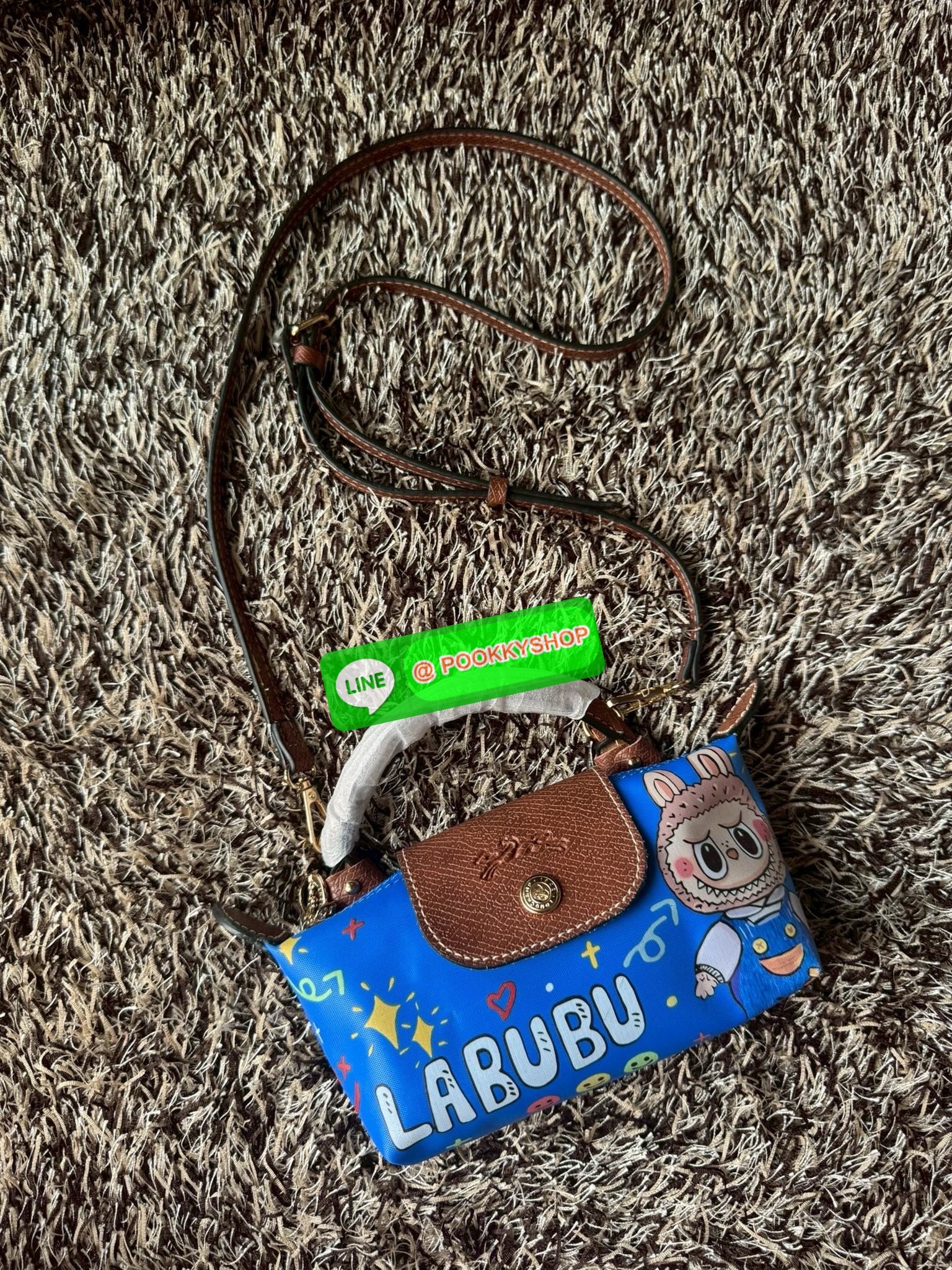 LONGCHAMP LE PLIAGE ORIGINAL X Labubu Pouch with handle เป็นการร่วมงานกัระหว่างแบรนด์ และยังกระเป๋าถือขนาดมินิทรงpouch ที่ด้านหน้ามีลวดลายน้องลาบูบู้ในแบบต่างๆ เปิดปิดระบบสองชั้น ได้ว่าของด้านในมีความปลอดภัย เหมาะอย่างยิ่งสำหรับสาวๆที่ชอบกระเป๋าขนาดมินิไซ