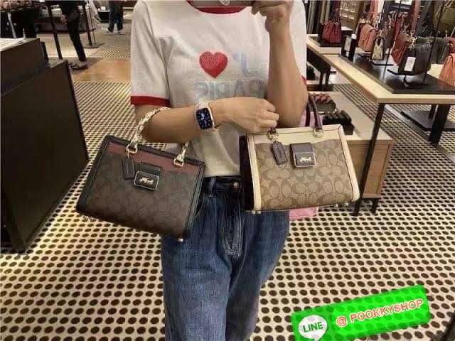 Coach Grace Carryall In Signature Canvas กระเป๋ารูปทรงสี่เหลี่ยมสุดคลาสสิก เป็นกระเป๋าอเนกประสงค์ที่สามารถใช้ได้แทบทุกโอกาส ไม่ว่าจะไปเรียน, ไปทำงาน, ไปเที่ยว หรือแม้แต่ไปชอปปิง ด้วยขนาดที่กำลังดี ไม่ใหญ่เทอะทะ แต่ก็ไม่เล็กจนเกินไป มาพร้อมหูหิ้วทั้งด้านบน