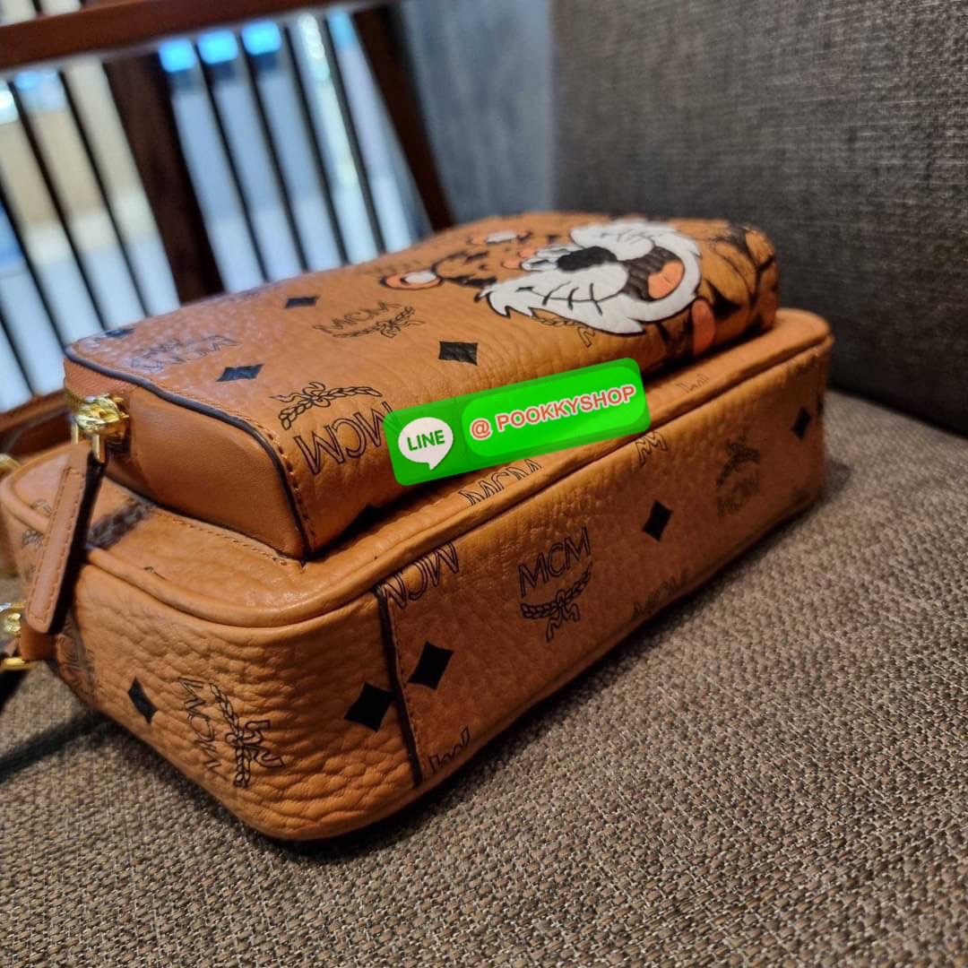 MCM KLASSIK CROSSBODY IN NEW YEAR TIGER VISETOS ใหม่ล่าสุด คอลเลคชั่นรับปีเสือ ของมันต้องมี กระเป๋าสะพายข้างทรงครอสบอดี้ โดดเด่นด้วยลายพริ้นท์น้องเสือคมสวย รุ่นนี้หนุ่มๆหรือสาวๆก็สะพายได้น้า ขนาดกำลังดี วัสดุหนังแคนวาสคุณภาพดี มีช่องหลัก 2 ช่อง เปิด-ปิดด้