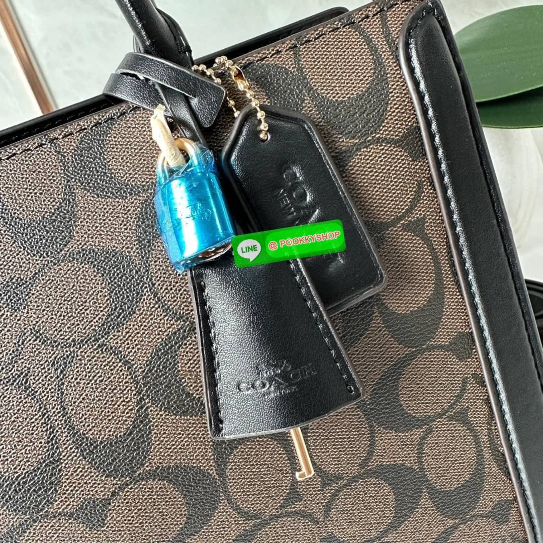 COACH ZOE CARRYALL IN SIGNATURE CANVAS (F87665) กระเป๋าถือหรือสะพาย ผู้ดีคุณนาย วัสดุหนังแคนวาส ตัดขอบหนังแท้ เปิด-ปิดด้วยซิปคู่ ตกแต่งด้วยตัวล็อคแม่กุญแจห้อยด้านหน้า ด้านในเป็นช่องกว้างใส่ของได้เยอะ มีสายสะพายยาว ถอด-ปรับระดับได้ สวย หรู ดูแพงมาก
