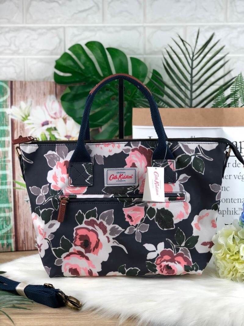 CATH KIDSTON HANDBAG กระเป๋าถือ/สะพายทรงสวย ด้านหน้ามีช่องซิปใส่ของจุกจิกได้ มีหมุดรองฐาน 4 มุม หูหิ้วมีหนังรองมือ เปิดปิดด้วยซิปบน ด้านในกว้างจุของได้เยอะ มีช่องซิปเล็ก 1 ช่อง มาพร้อมสายสะพายยาวถอดและปรับสายได้ รุ่นนี้น้ำหนักเบา ใช้งานง่ายได้หลายโอกาส มี