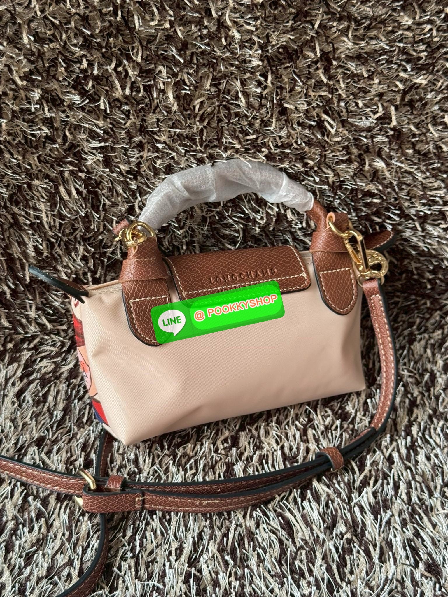LONGCHAMP LE PLIAGE ORIGINAL X Labubu Pouch with handle เป็นการร่วมงานกัระหว่างแบรนด์ และยังกระเป๋าถือขนาดมินิทรงpouch ที่ด้านหน้ามีลวดลายน้องลาบูบู้ในแบบต่างๆ เปิดปิดระบบสองชั้น ได้ว่าของด้านในมีความปลอดภัย เหมาะอย่างยิ่งสำหรับสาวๆที่ชอบกระเป๋าขนาดมินิไซ