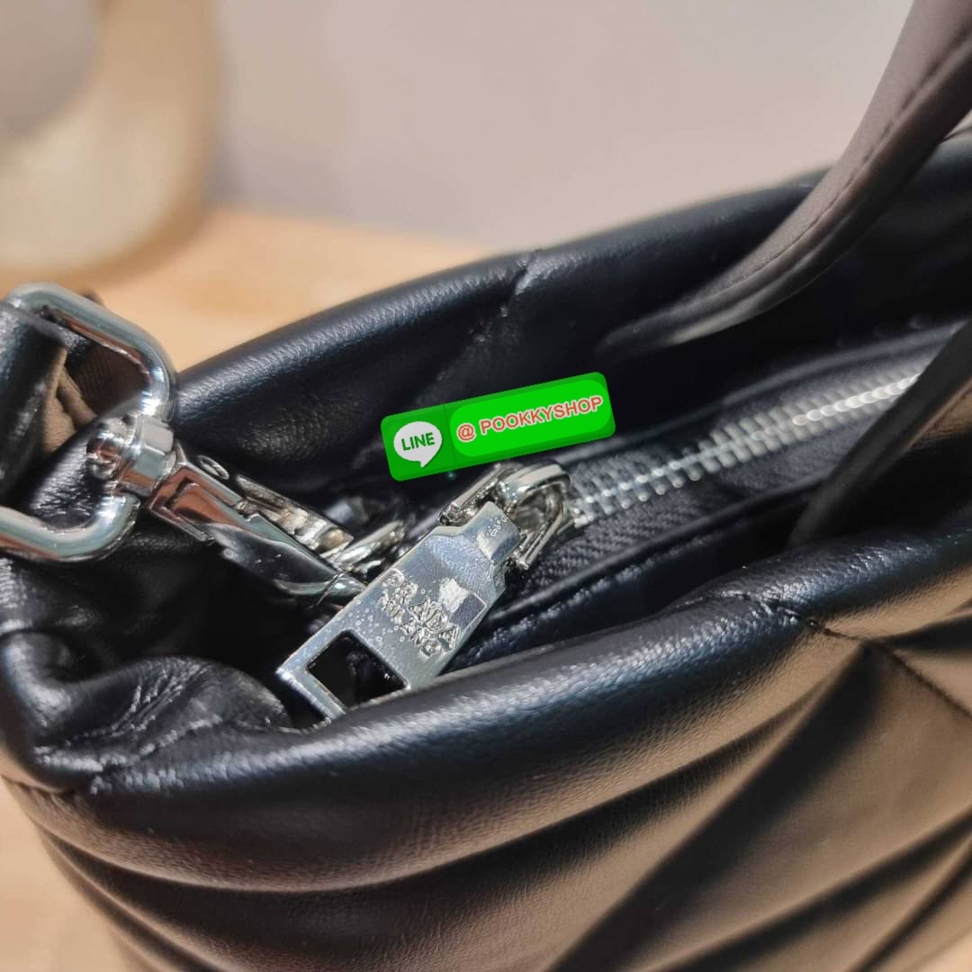 PRADA LEATHER PADDED BAG ใหม่ล่าสุด กับคอลเลคชั่นที่ทำออกมาตอบโจทย์ได้ทุกไลฟ์สไตล์ และเป็นยูนิเซ็กส์ กับกระเป๋าทรงโท้ท ขนาดกำลังดี วัสดุหนังแท้ ตัดเย็บเดินเส้นลายตาราง ปากกระเป๋ามีซิปเปิดปิด ภายในเป็นช่องโล่ง มีช่องแยกให้ มาพร้อมสะพายข้างและใบลูก ให้ได้สน