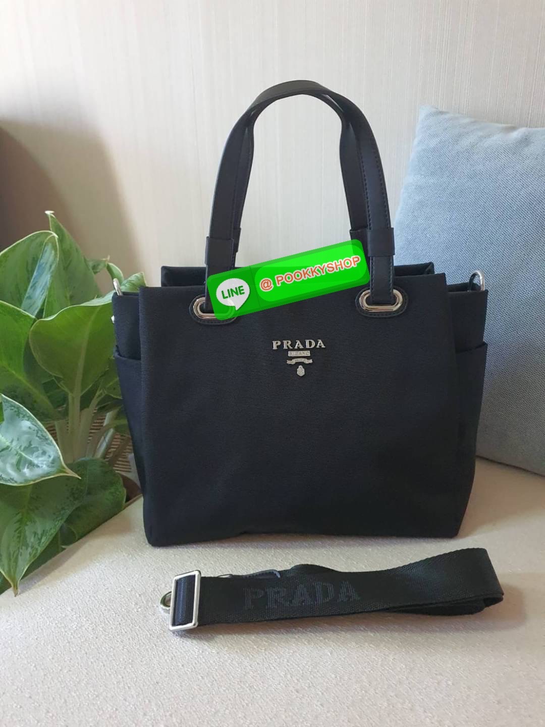 พร้อมส่งรุ่นใหม่ จากแบรนด์ PRADA งานพรีเมี่ยมกิ๊ฟท์จากเคาเตอร์ต่างประเทศค่ะ ทรง Handbag มาพร้อมสายยาว วัสดุทำจากผ้า POLYESTER สามารถกันน้ำได้ ด้านหน้ามีโลโก้แบรนด์ ด้านหลังมีช่องซิป สำหรับใส่ของ เปิดปิดด้วยซิป ภายในมีช่องซิป และช่องใส่ของแบ่ง บุผ้าลายแบรน