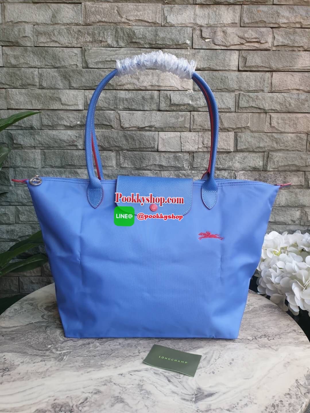 Longchamp Le Pliage Club Tote Bag Size L หูยาว วัสดุเนื้อผ้า Nylon Canvas เคลือบกันนำ้ ตัดด้วยหนังแท้ที่มีน้ำหนักเบา ดีไซน์เรียบง่ายแต่เต็มไปด้วยความคลาสสิก จนเป็นที่ชื่นชอบไปทั่วโลก Longchamp ปรับโฉม LE PLIAGE ด้วยการปักลายรูปม้า-ตราสัญลักษณ์ของแบรนด์บนผ