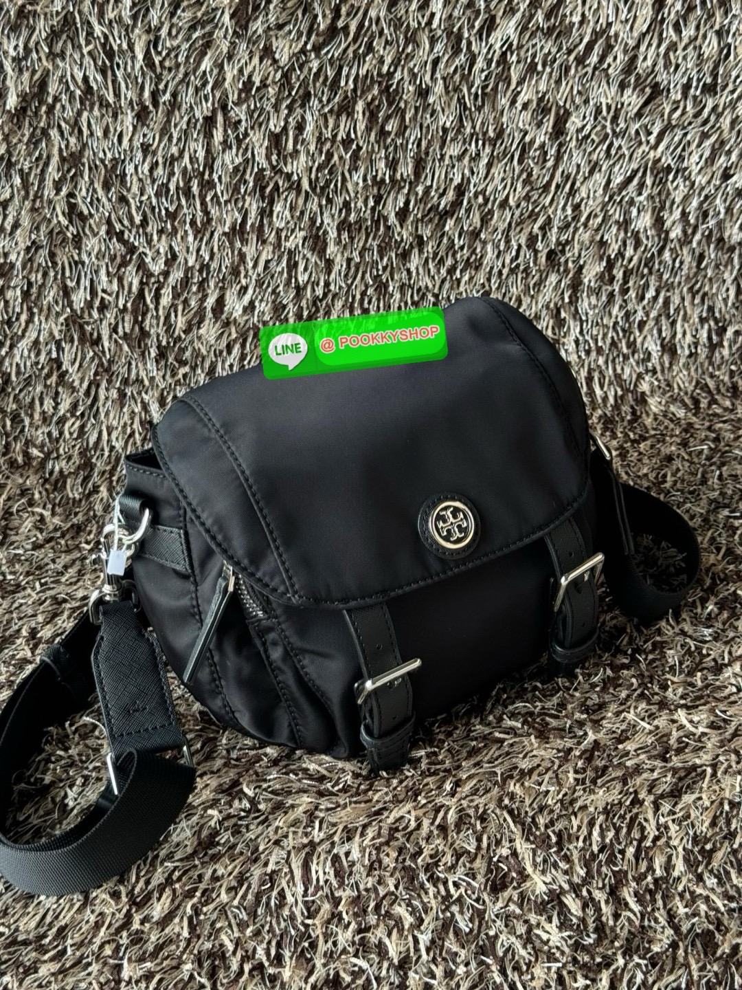 TORY BURCH VIRGINIA SMALL MESSENGER เป็นกระเป๋าที่มีรูปแบบการเปิด-ปิดด้วยกระดุมแม่เหล็ก ทำให้ปากกระเป๋าเปิดง่ายและหยิบสิ่งของสะดวก ซึ่งภายในฐานกระเป๋ามีความกว้างขวางพอสมควร เก็บสิ่งของต่าง ๆ ได้ดั่งใจ มาพร้อมดีไซน์เรียบง่ายสีดำประดับด้วยโลโก้แบรนด์อันเป็น