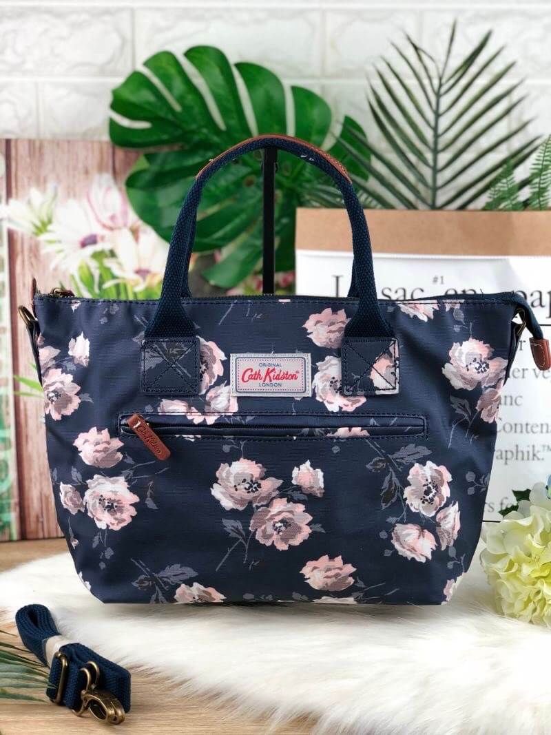 CATH KIDSTON HANDBAG กระเป๋าถือ/สะพายทรงสวย ด้านหน้ามีช่องซิปใส่ของจุกจิกได้ มีหมุดรองฐาน 4 มุม หูหิ้วมีหนังรองมือ เปิดปิดด้วยซิปบน ด้านในกว้างจุของได้เยอะ มีช่องซิปเล็ก 1 ช่อง มาพร้อมสายสะพายยาวถอดและปรับสายได้ รุ่นนี้น้ำหนักเบา ใช้งานง่ายได้หลายโอกาส มี