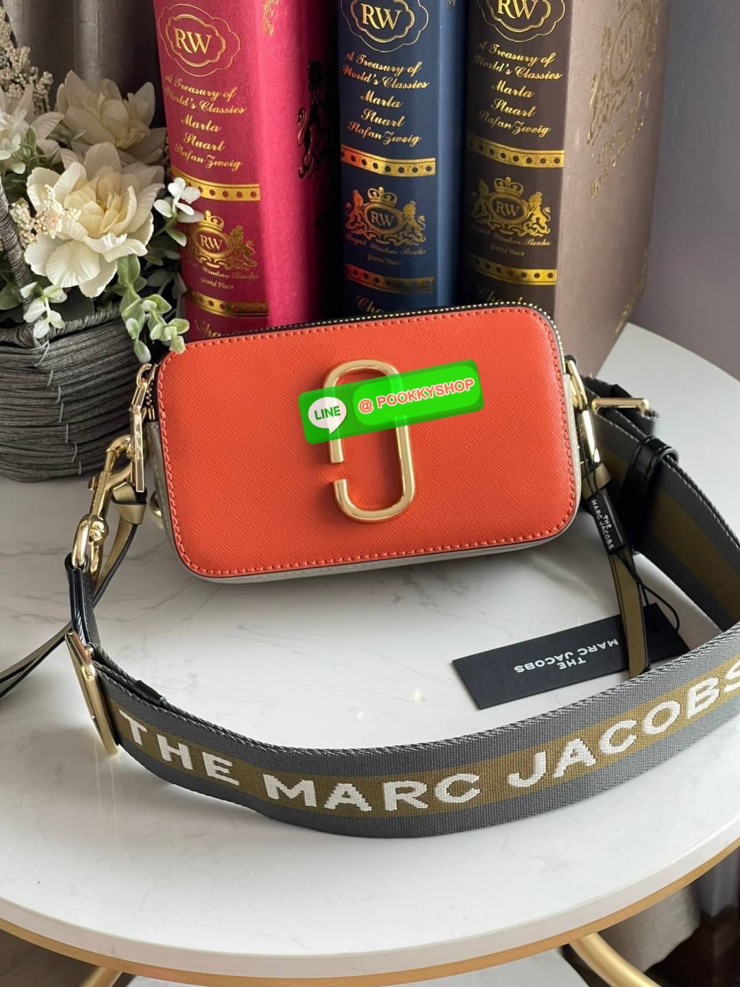 Marc Jacobs Snapshot Bag กระเป๋าแบรนด์ดังจากสัญชาติอเมริกัน นับได้ว่ารุ่นนี้เป็นรุ่นทรงฮิตของ marc jacobs เลยทีเดียว โดยด้านหน้ากระเป๋าจะเป็นโลโก้แบบโลหะที่เป็นสัญลักษณ์ของแบรนด์นี้ มาพร้อมสายสะพายที่จะสะพายยังไงก็ดูโดดเด่น เพราะขนาดใหญ่ที่สกรีนตัวอักษร m