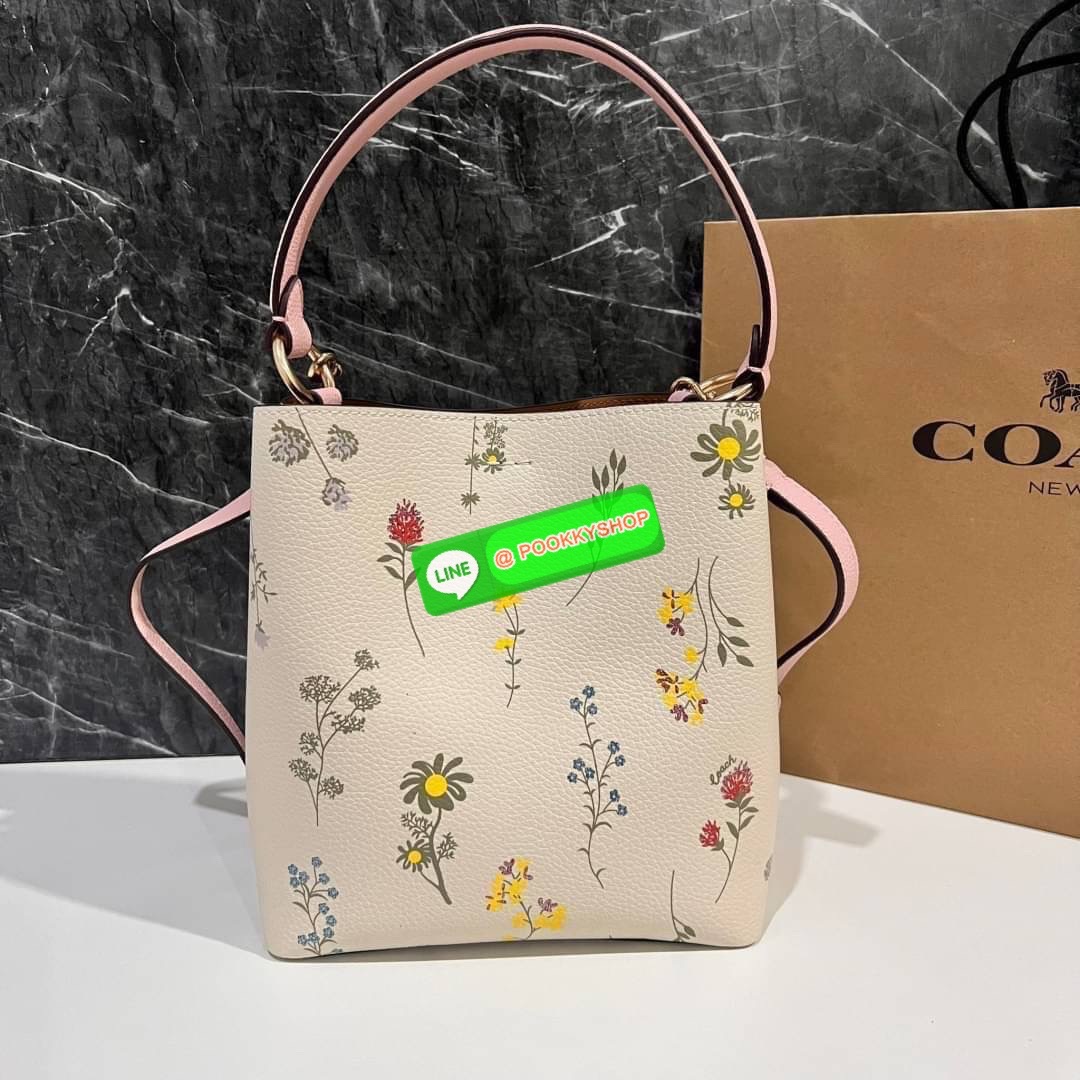 COACH C3598 SMALL TOWN BUCKET WITH SPACED WILDFLOWER PRINT มีความน่ารักละมุนมาก กระเป๋าทรงบัคเก็ต ดีไซน์ดอกไม้คละรอบใบ วัสดุหนังแท้ปากกระเป๋าเปิด-ปิดด้วยกระดุมแม่เหล็ก 2 มีหูจับในตัวและสายสะพายข้าง ภายในโล่งกว้าง มีช่องซิปแยกสัดส่วนตรงกลาง สายสะพายปรับระด