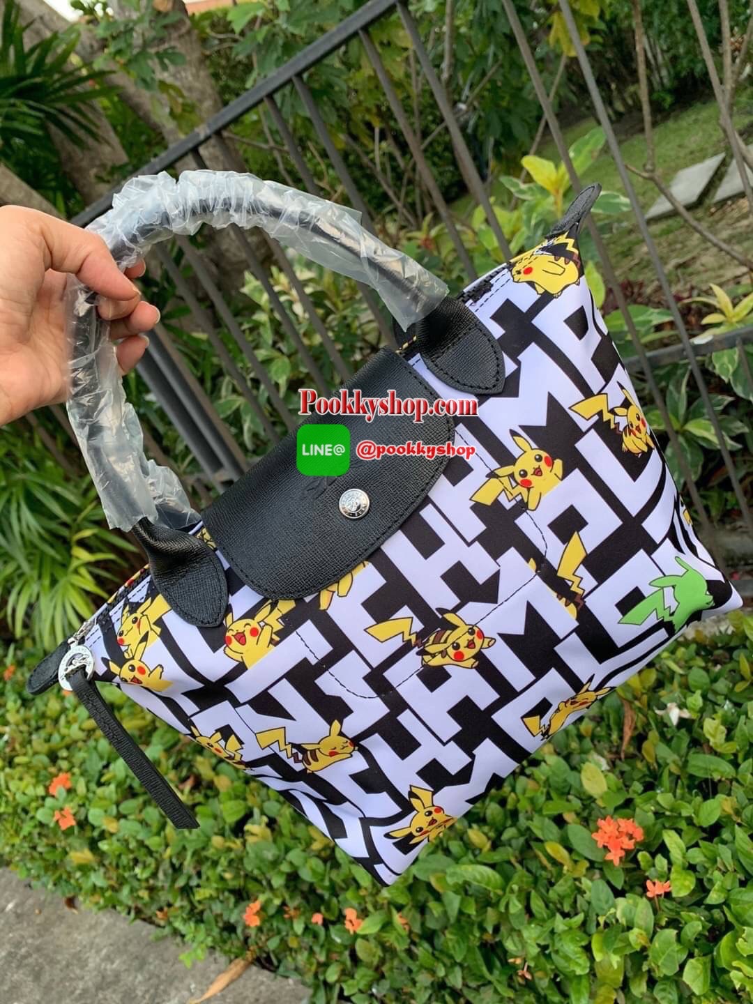 LONGCHAMP X POKÉMON SHOULDER BAG เพราะรู้ว่า &quot;เลอ ปลิยาจ&quot; (Le Pliage) เป็นกระเป๋าไอคอนิคยอดนิยมของคนทุกเพศทุกวัย ไม่ว่าจะเป็นคนธรรมดาหรือเซเล็บ ลองฌอมป์ก็เลยจัดให้ &quot;ปิกาจู&quot; ไปวิ่งเล่นอยู่บนกระเป๋าที่ออกมาเป็นซีรีส์ซะเลย และยังคงความ Le