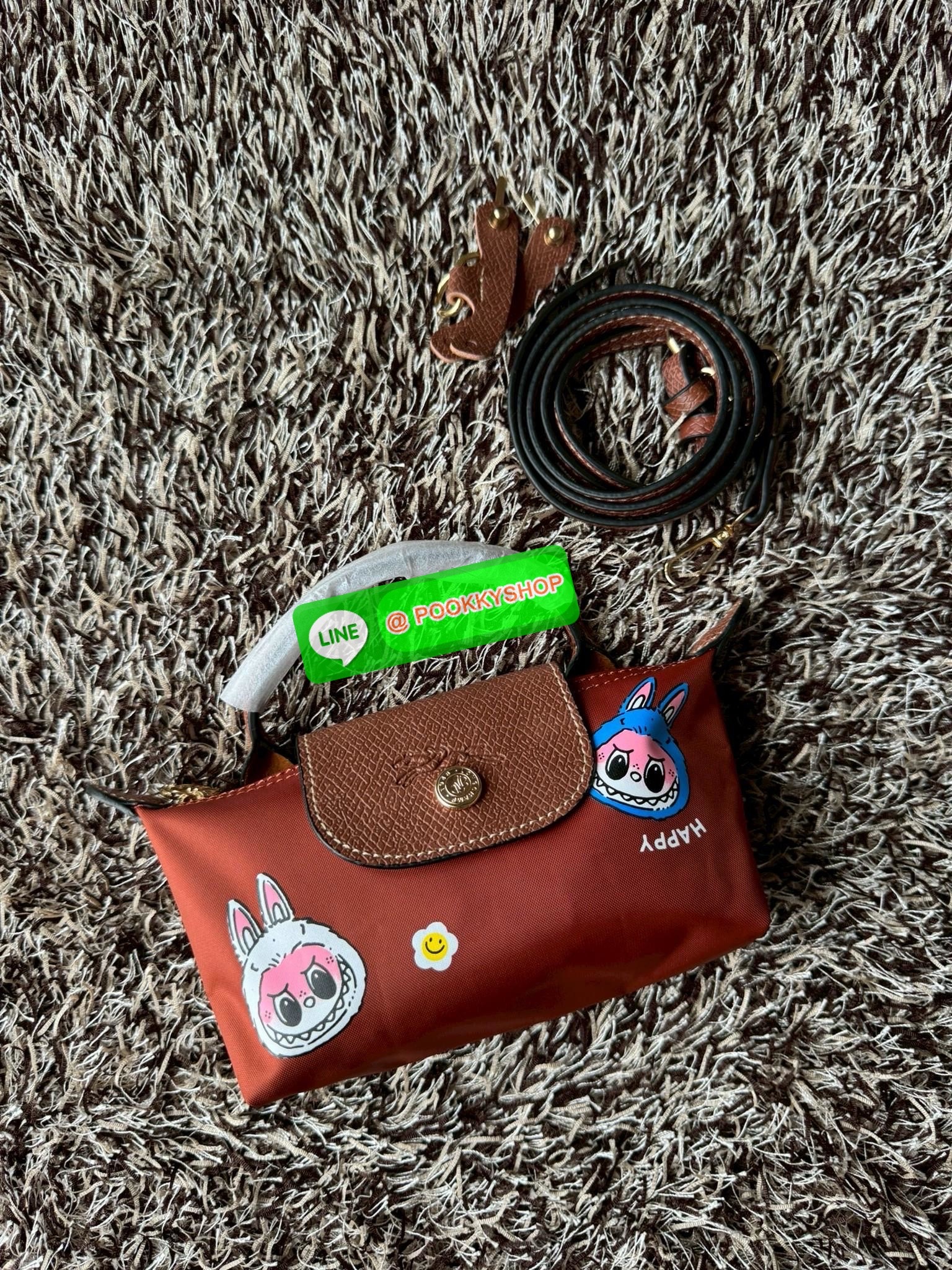 LONGCHAMP LE PLIAGE ORIGINAL X Labubu Pouch with handle เป็นการร่วมงานกัระหว่างแบรนด์ และยังกระเป๋าถือขนาดมินิทรงpouch ที่ด้านหน้ามีลวดลายน้องลาบูบู้ในแบบต่างๆ เปิดปิดระบบสองชั้น ได้ว่าของด้านในมีความปลอดภัย เหมาะอย่างยิ่งสำหรับสาวๆที่ชอบกระเป๋าขนาดมินิไซ