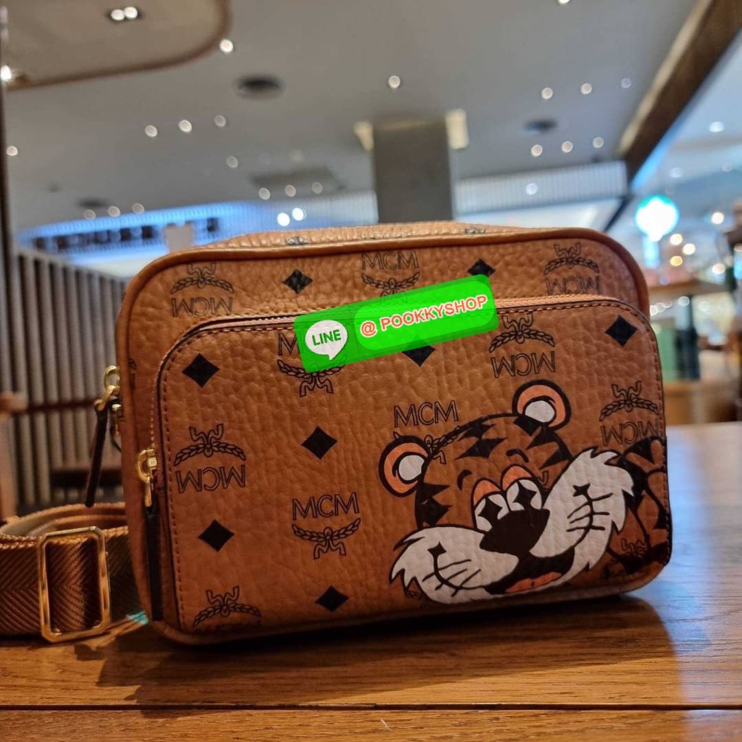 MCM KLASSIK CROSSBODY IN NEW YEAR TIGER VISETOS ใหม่ล่าสุด คอลเลคชั่นรับปีเสือ ของมันต้องมี กระเป๋าสะพายข้างทรงครอสบอดี้ โดดเด่นด้วยลายพริ้นท์น้องเสือคมสวย รุ่นนี้หนุ่มๆหรือสาวๆก็สะพายได้น้า ขนาดกำลังดี วัสดุหนังแคนวาสคุณภาพดี มีช่องหลัก 2 ช่อง เปิด-ปิดด้