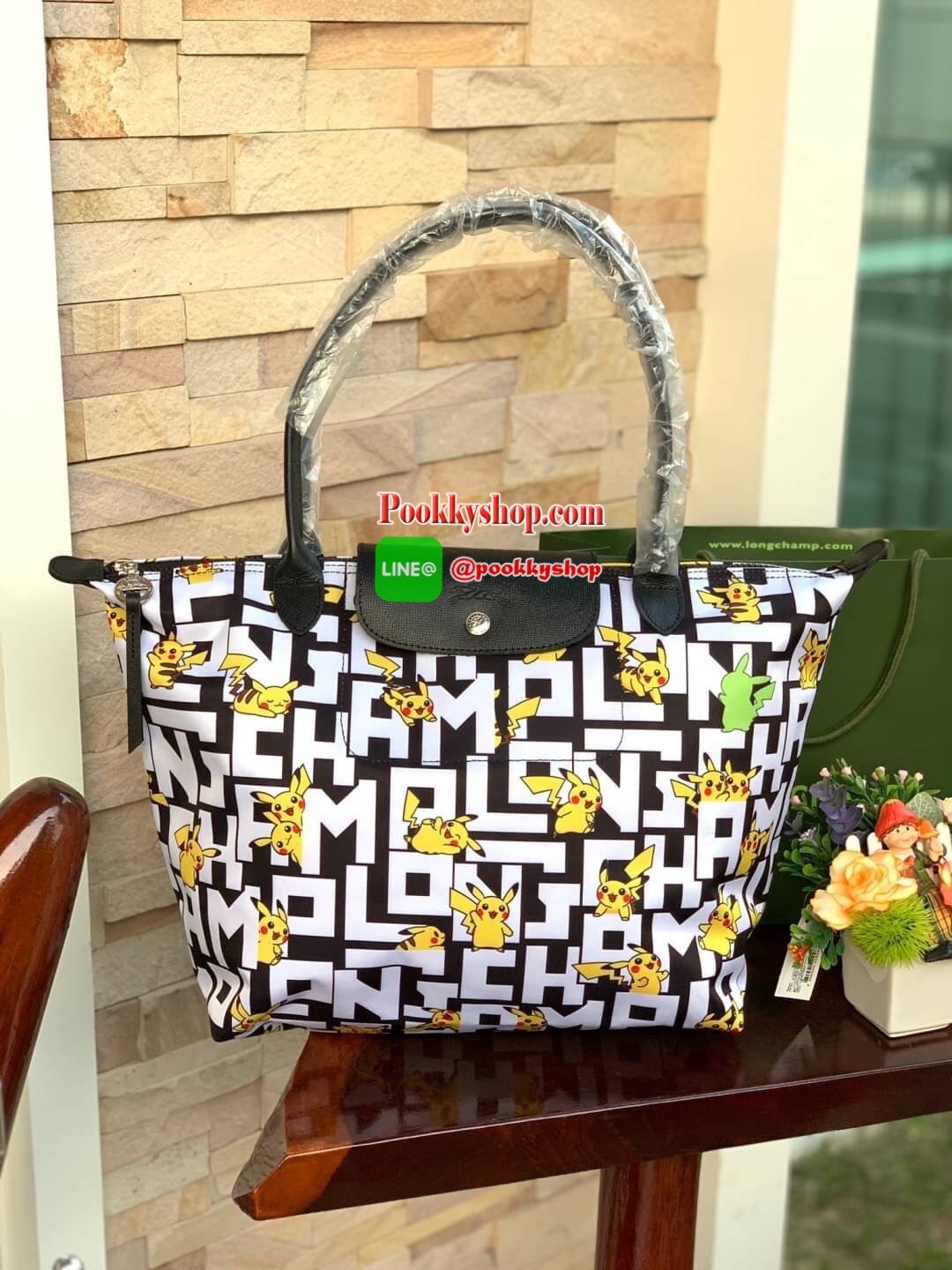 LONGCHAMP X POKÉMON SHOULDER BAG เพราะรู้ว่า &quot;เลอ ปลิยาจ&quot; (Le Pliage) เป็นกระเป๋าไอคอนิคยอดนิยมของคนทุกเพศทุกวัย ไม่ว่าจะเป็นคนธรรมดาหรือเซเล็บ ลองฌอมป์ก็เลยจัดให้ &quot;ปิกาจู&quot; ไปวิ่งเล่นอยู่บนกระเป๋าที่ออกมาเป็นซีรีส์ซะเลย และยังคงความ Le
